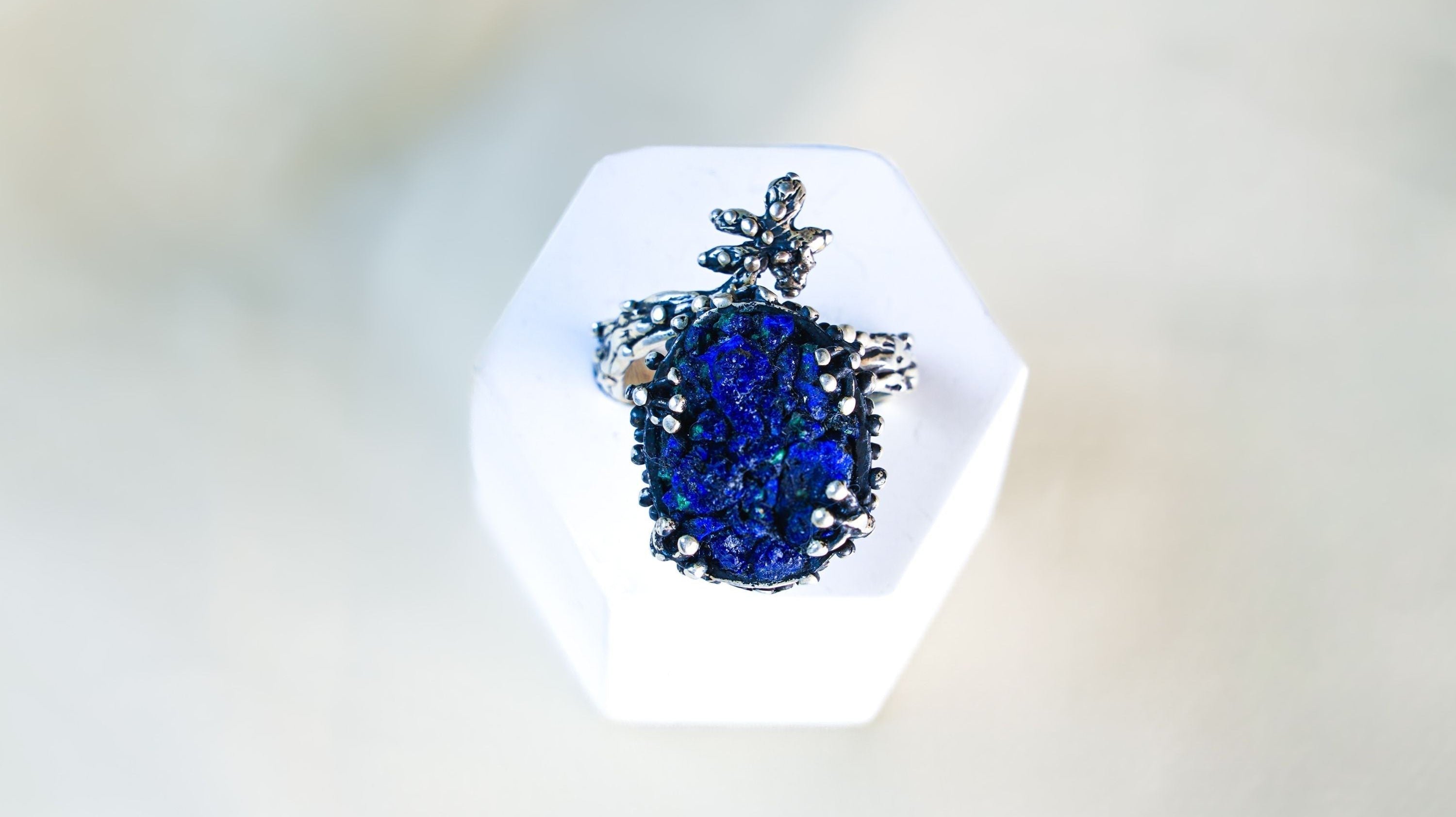 Handcrafted raw lapis lazuli sterling silver ring on a white pedestal