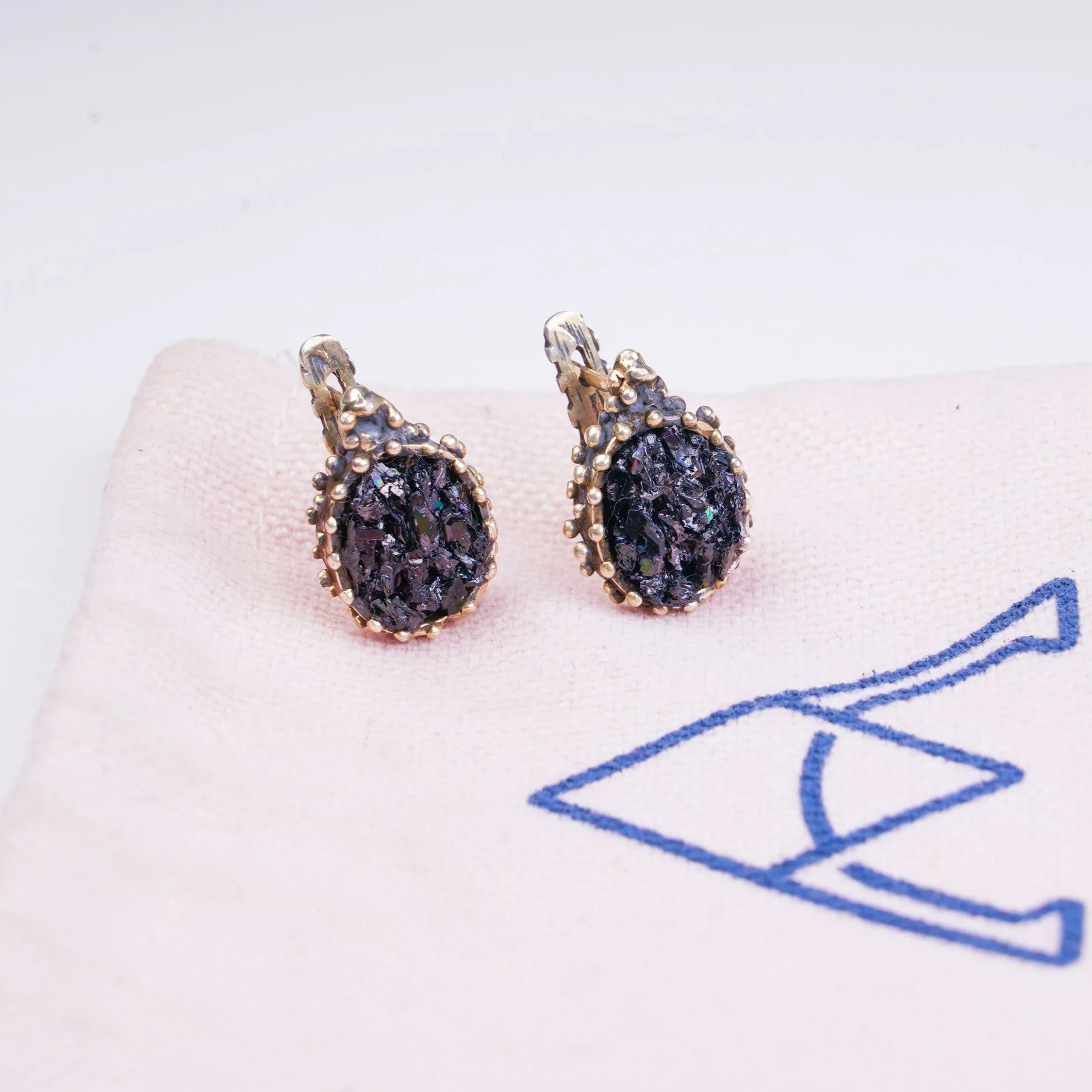 Black moissanite earrings on branded fabric aesthetic jewelry presentation