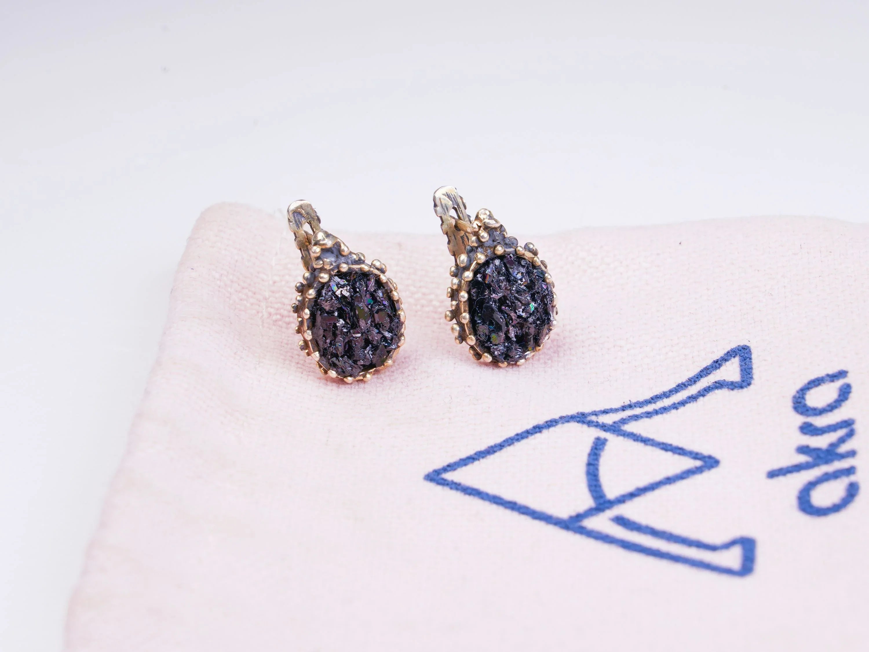 Black moissanite earrings on branded fabric aesthetic jewelry presentation