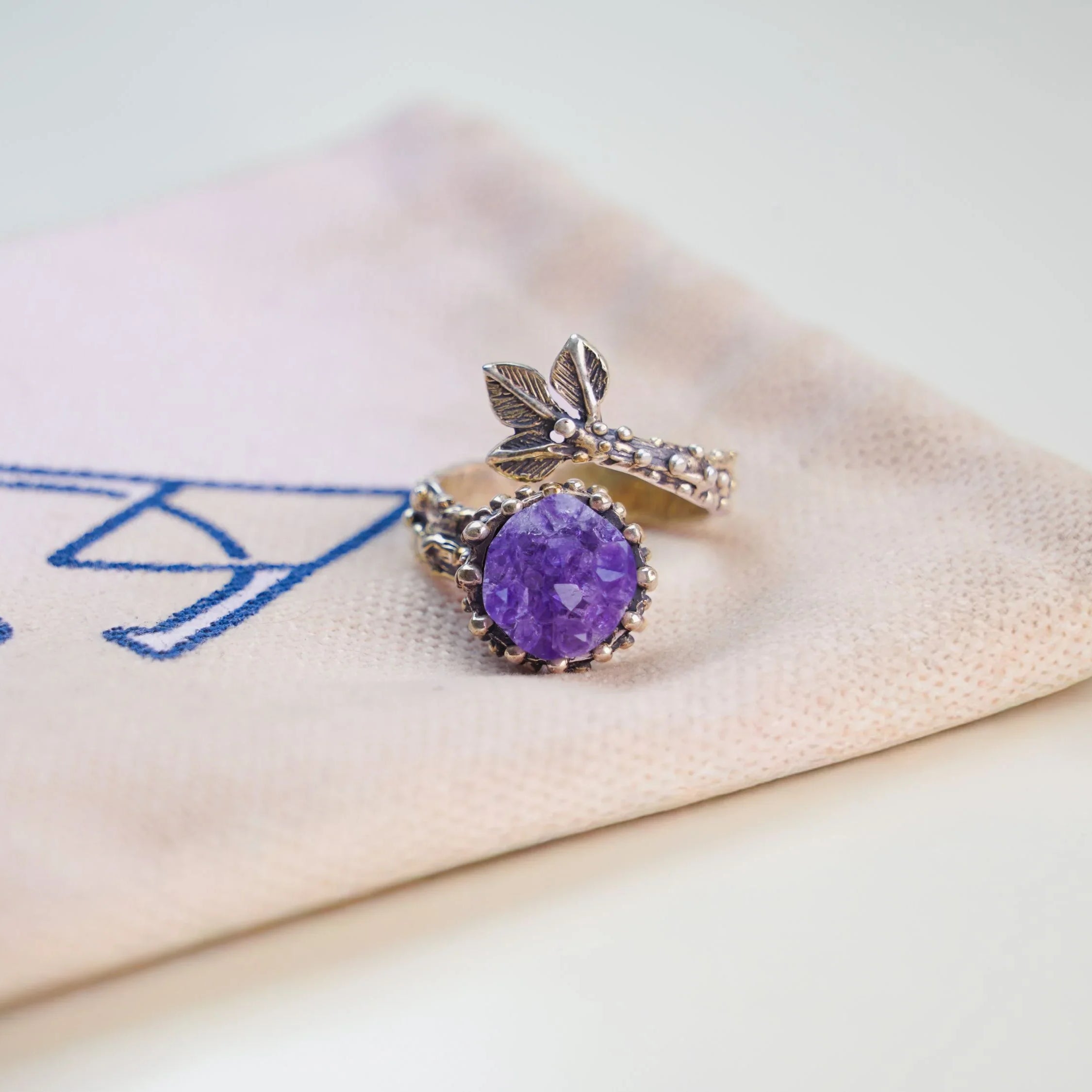 Amethyst ring on branded fabric minimalist jewelry aesthetic presentation