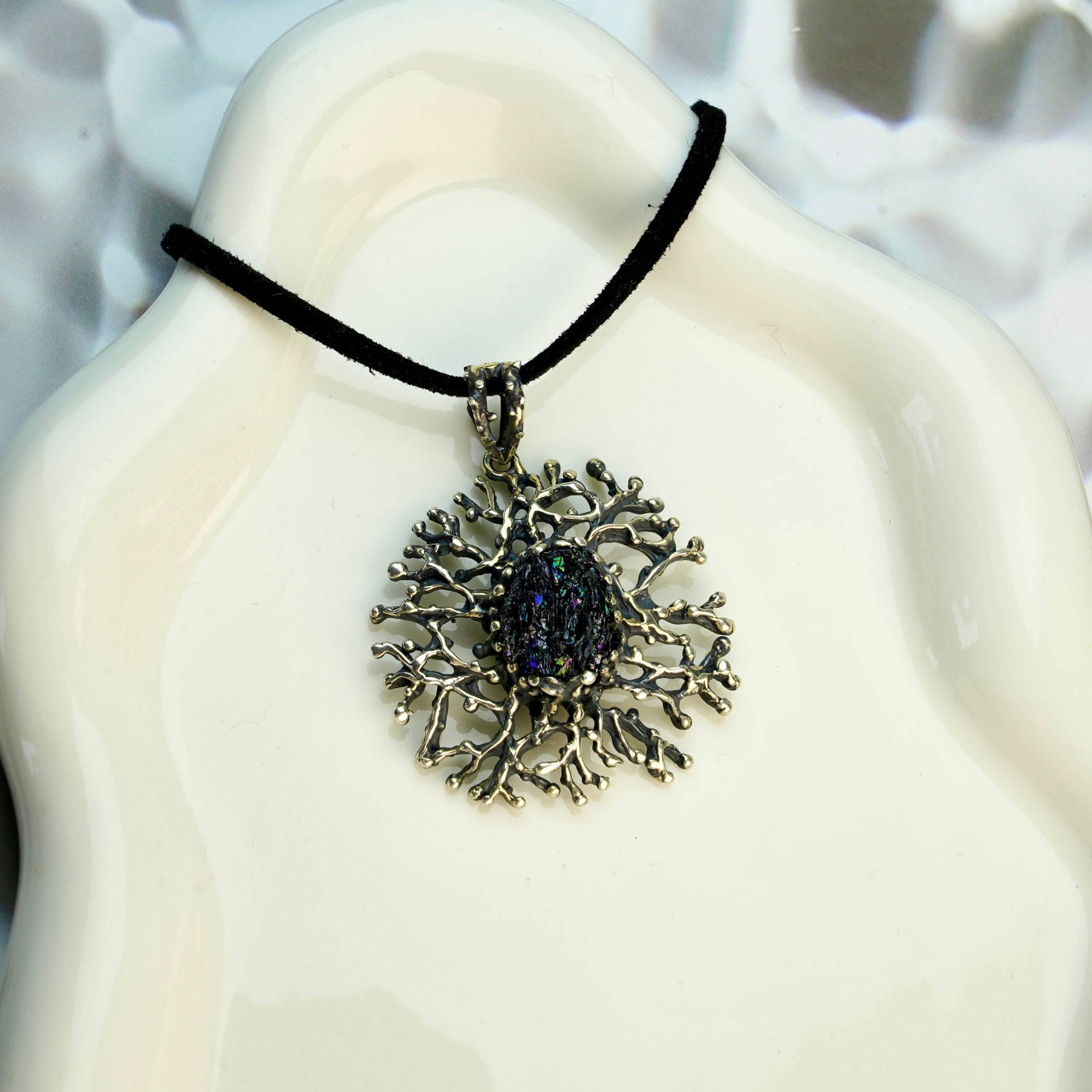 tourmaline pendant necklace on display, raw dark crystal sterling silver jewelry