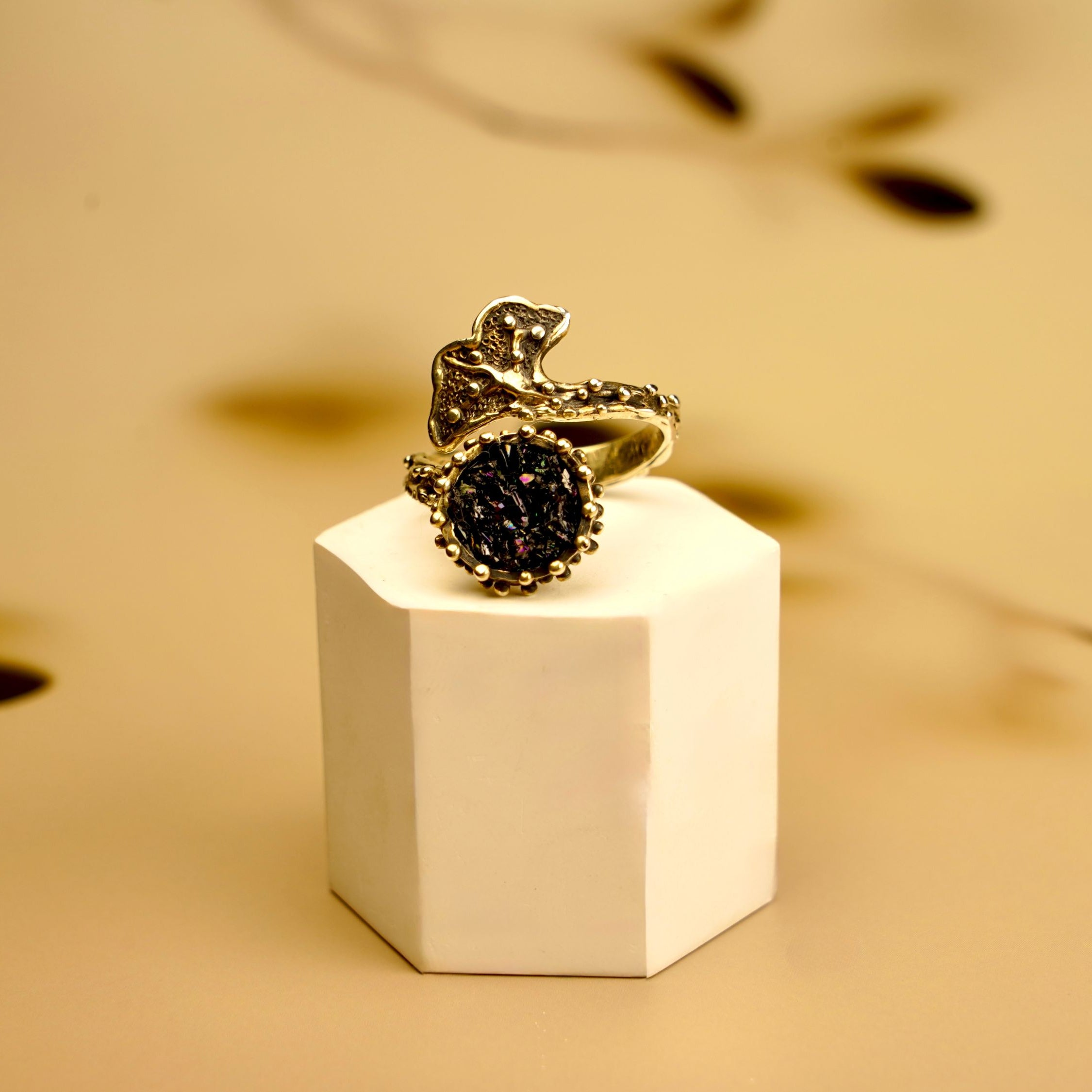 Black tourmaline ring adjustable sterling silver statement ring on pedestal minimal luxury background