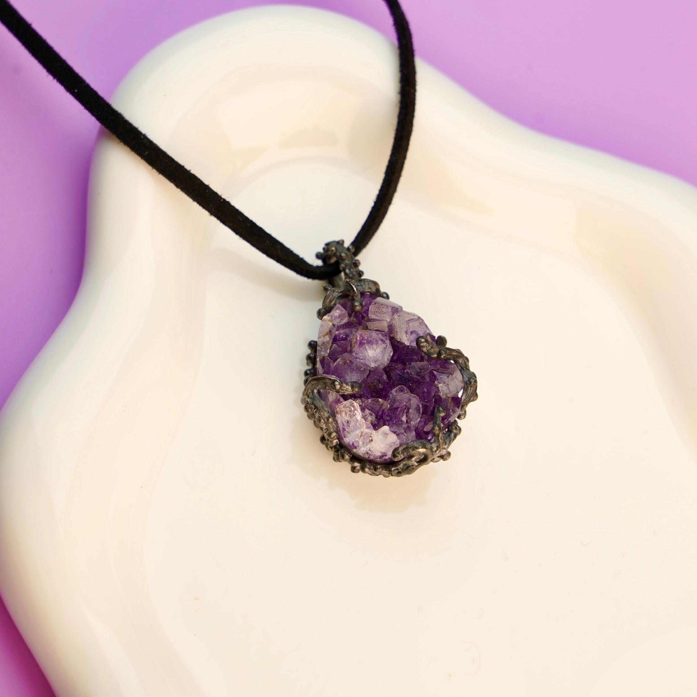 amethyst pendant necklace on display, raw purple crystal sterling silver jewelry