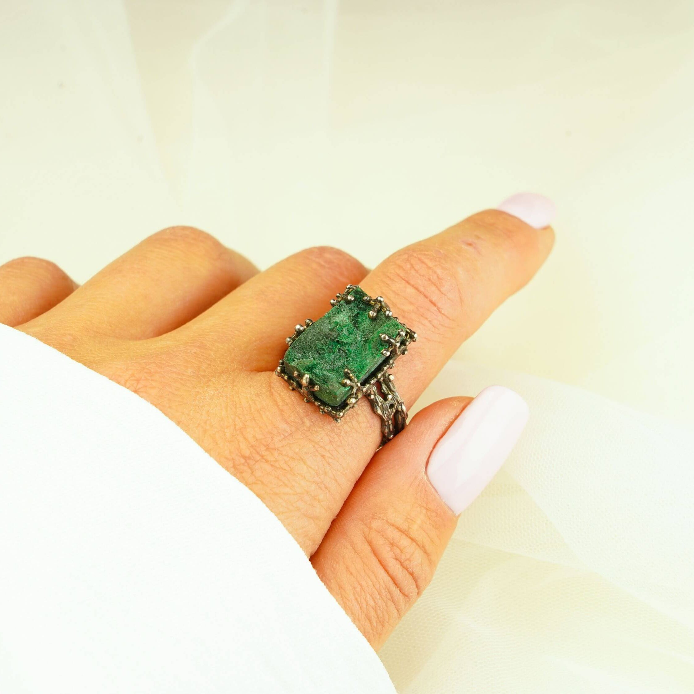 Statement raw malachite stone ring worn on finger showing large rectangular gemstone size