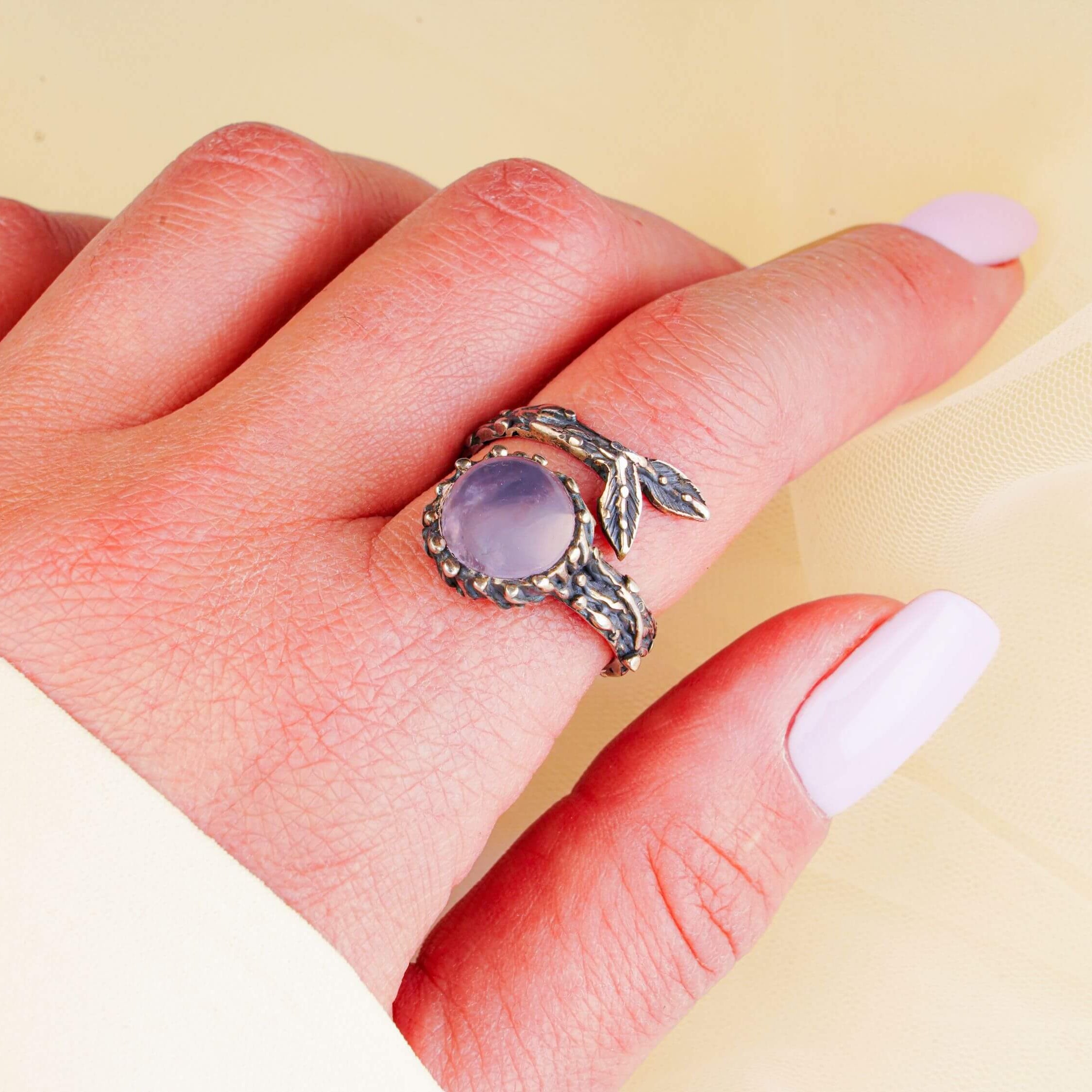 Ethereal rose quartz ring worn on hand showing the delicate pink gemstone and silver branch wrap