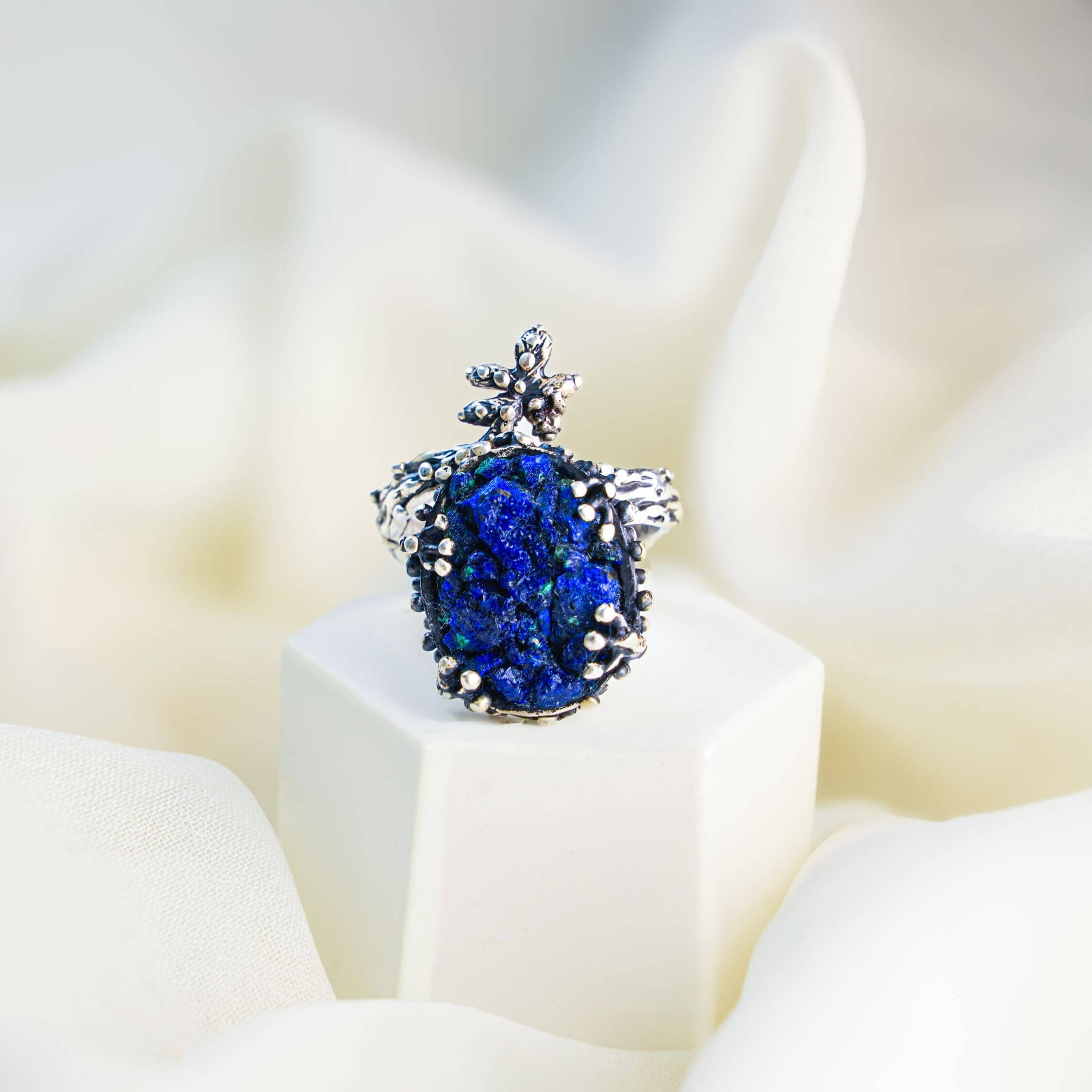 Macro shot of the natural lapis lazuli texture with golden pyrite flecks in a rustic silver setting