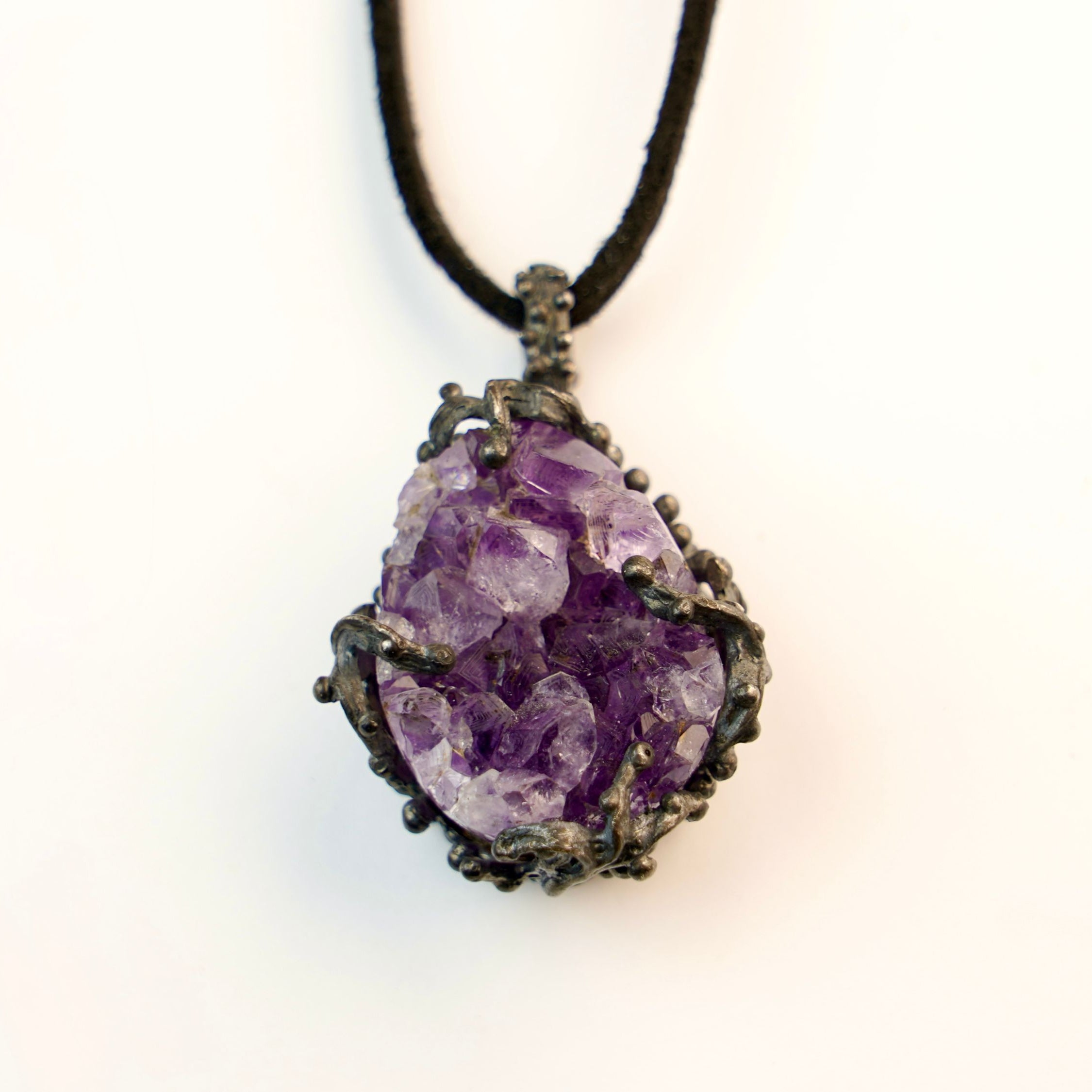 close up raw amethyst crystal pendant, natural purple gemstone texture detail