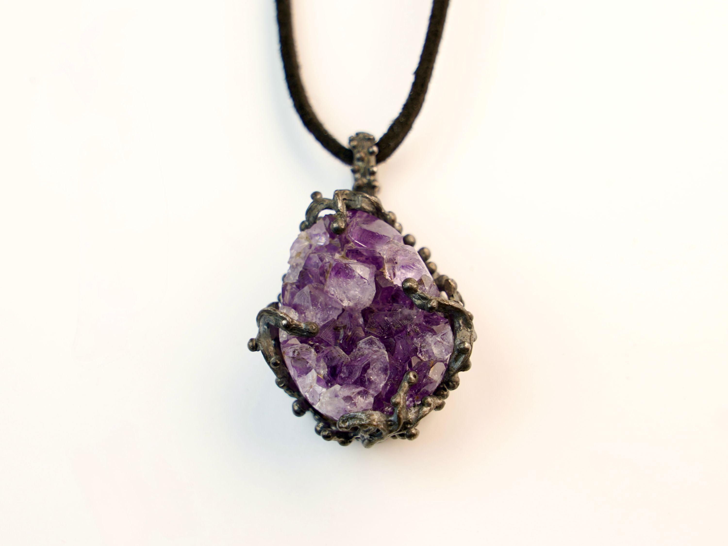 close up raw amethyst crystal pendant, natural purple gemstone texture detail