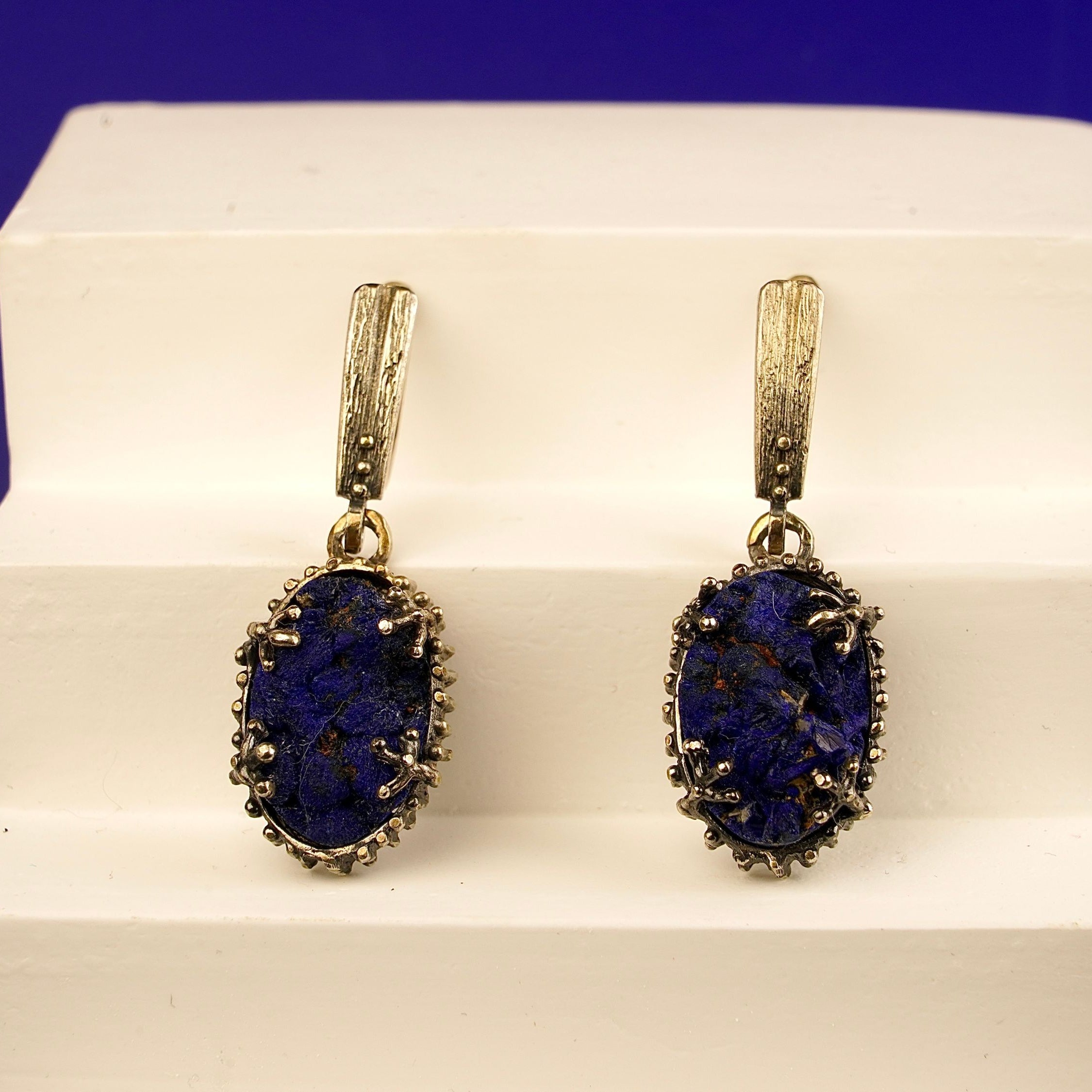 Close up lapis lazuli earrings deep blue textured stone detail silver setting