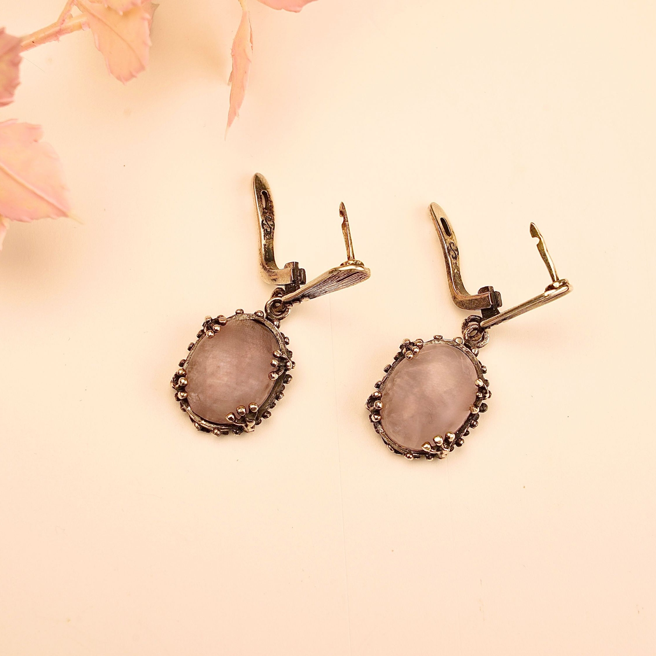 close up rose quartz earrings, soft pink gemstone glow detail