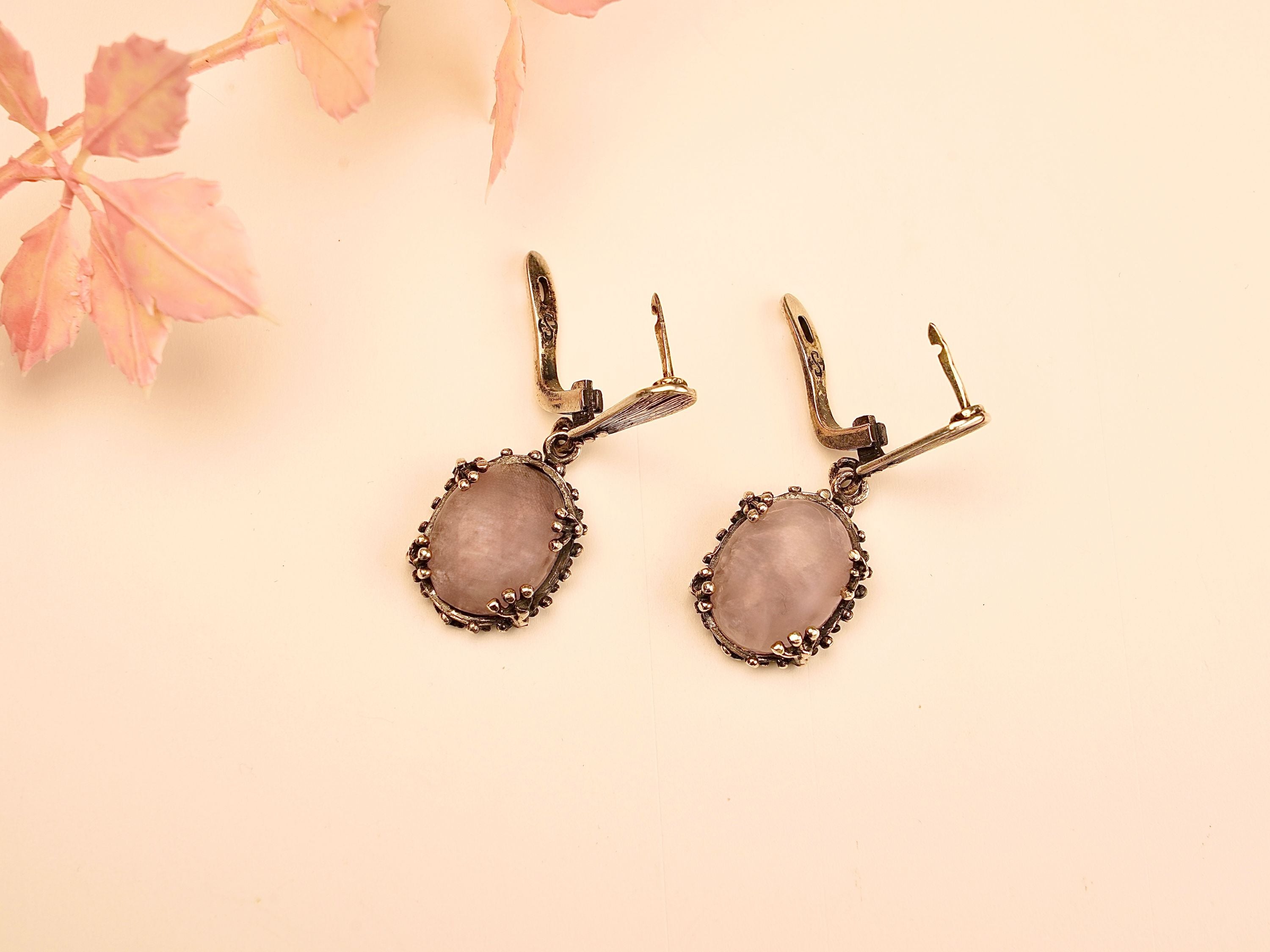 close up rose quartz earrings, soft pink gemstone glow detail