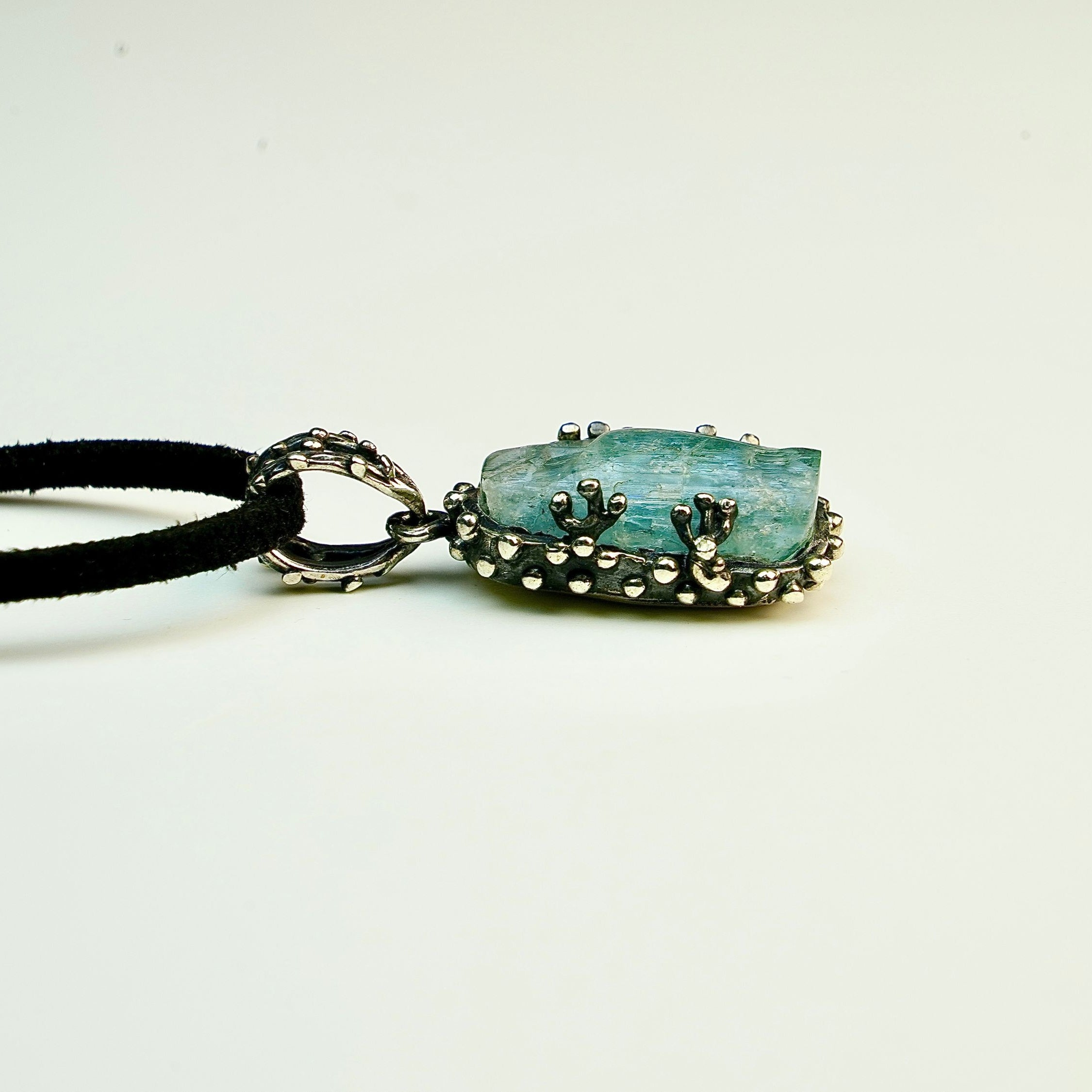 Close up aquamarine crystal raw texture blue gemstone detail sterling silver pendant