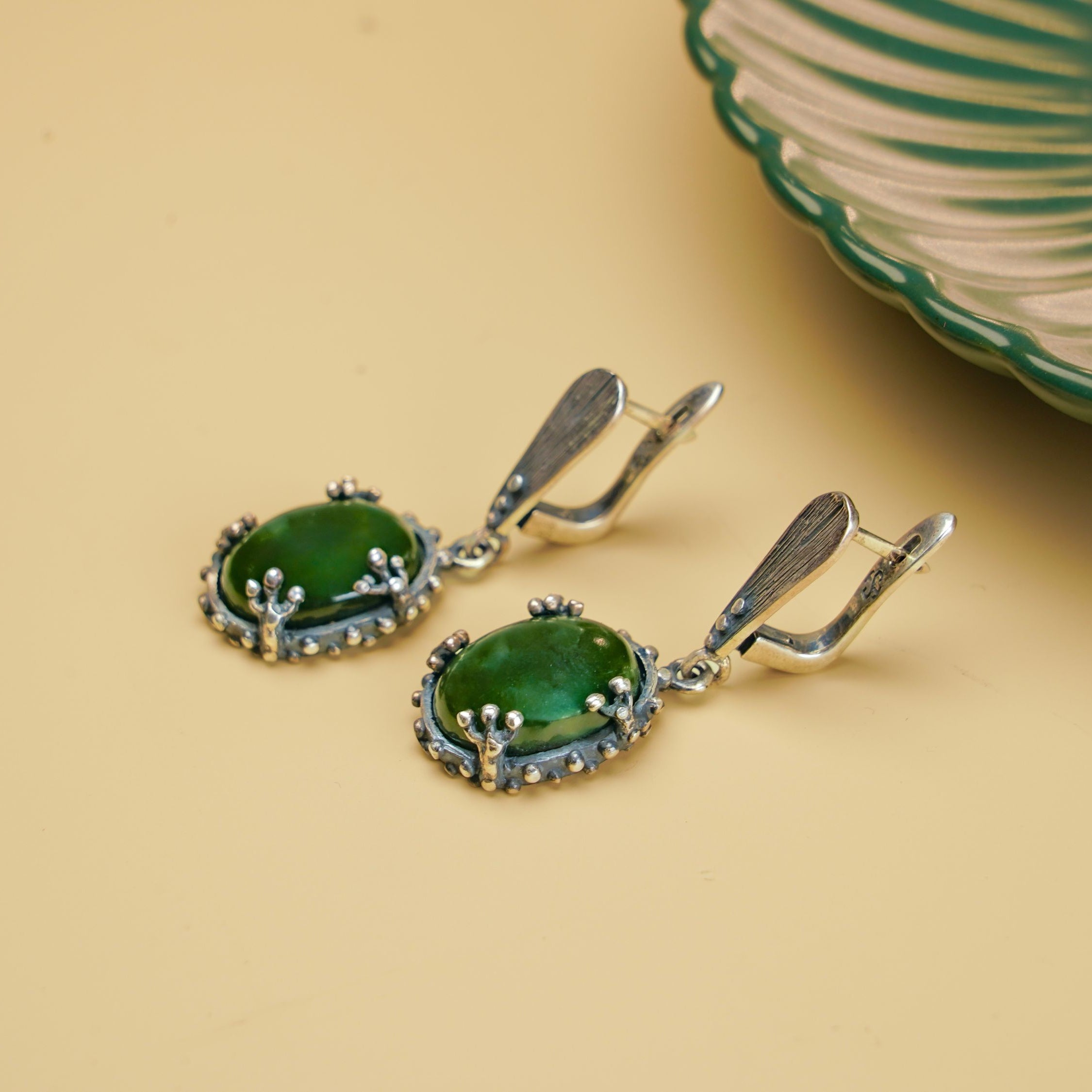 Close up jade earrings green gemstone texture detail silver setting