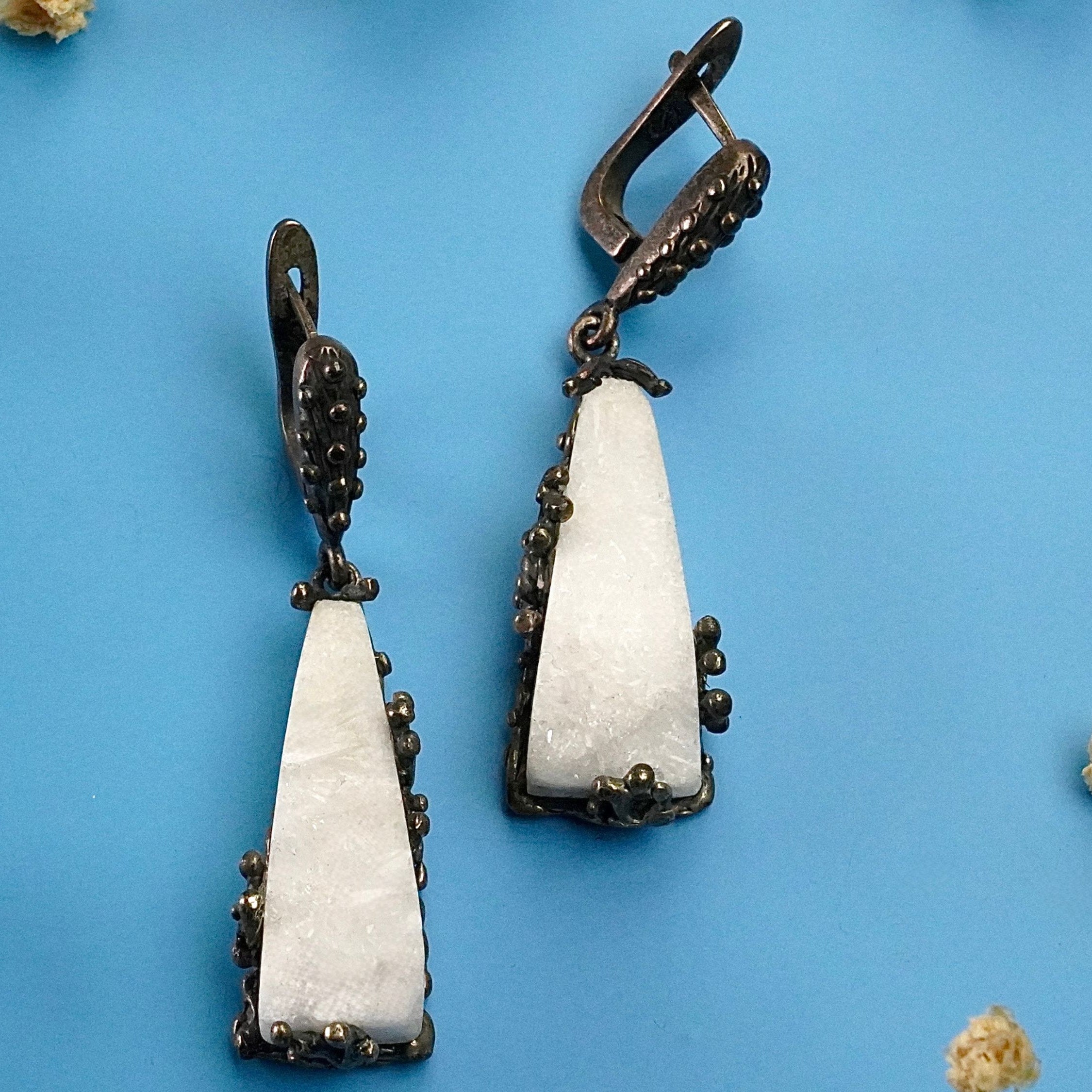 Close up moonstone earrings raw white crystal texture detail silver setting