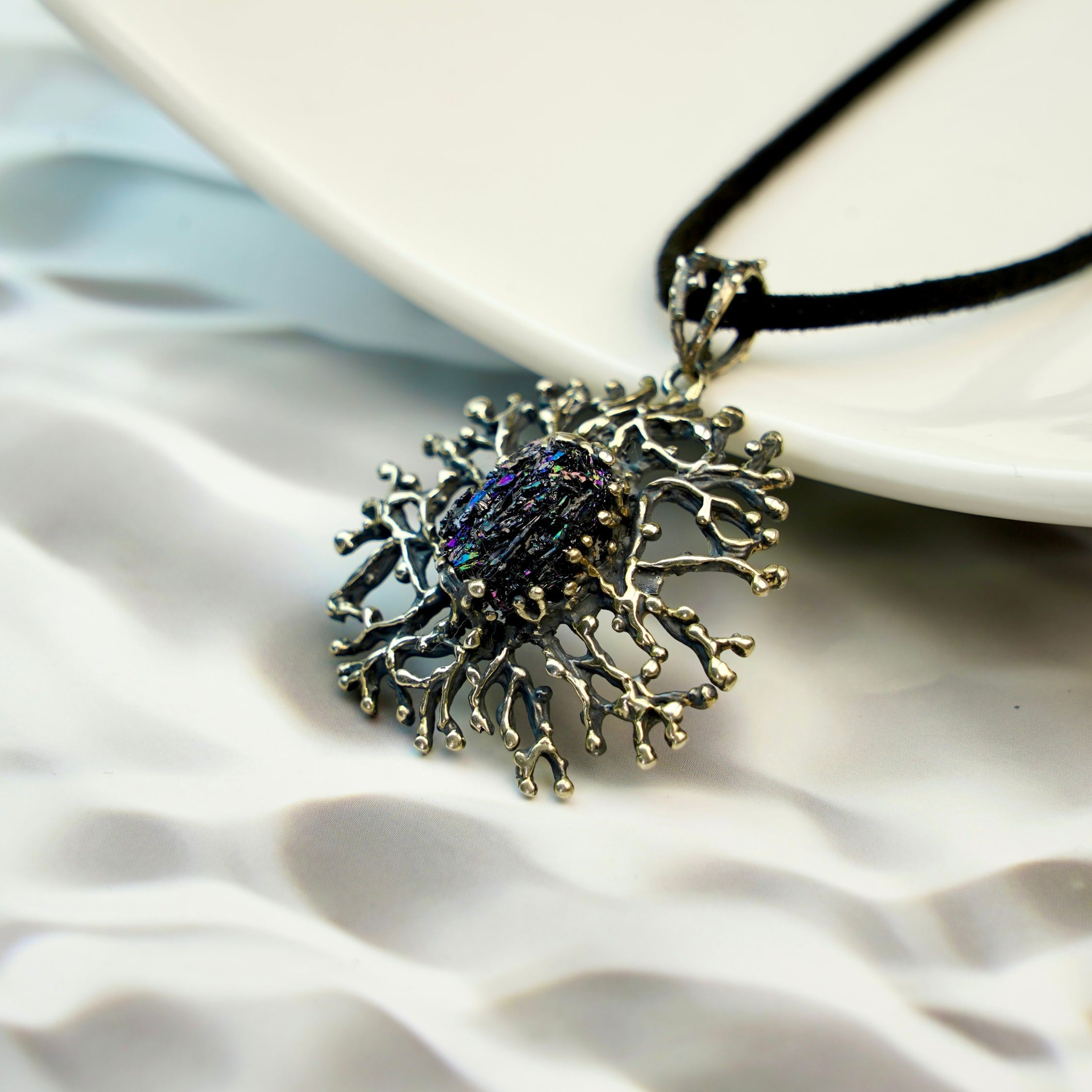 close up raw tourmaline pendant, natural dark crystal texture detail