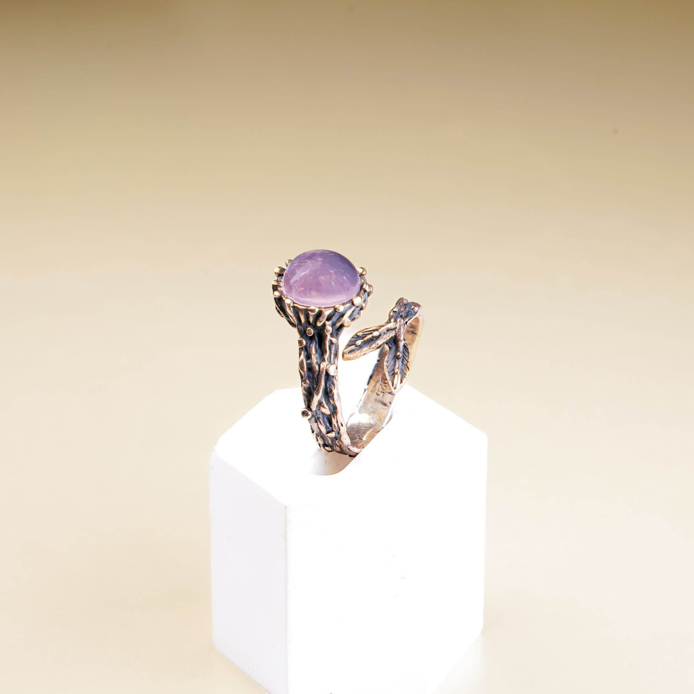 Side profile of a botanical style rose quartz ring showcasing the detailed silver branch texture