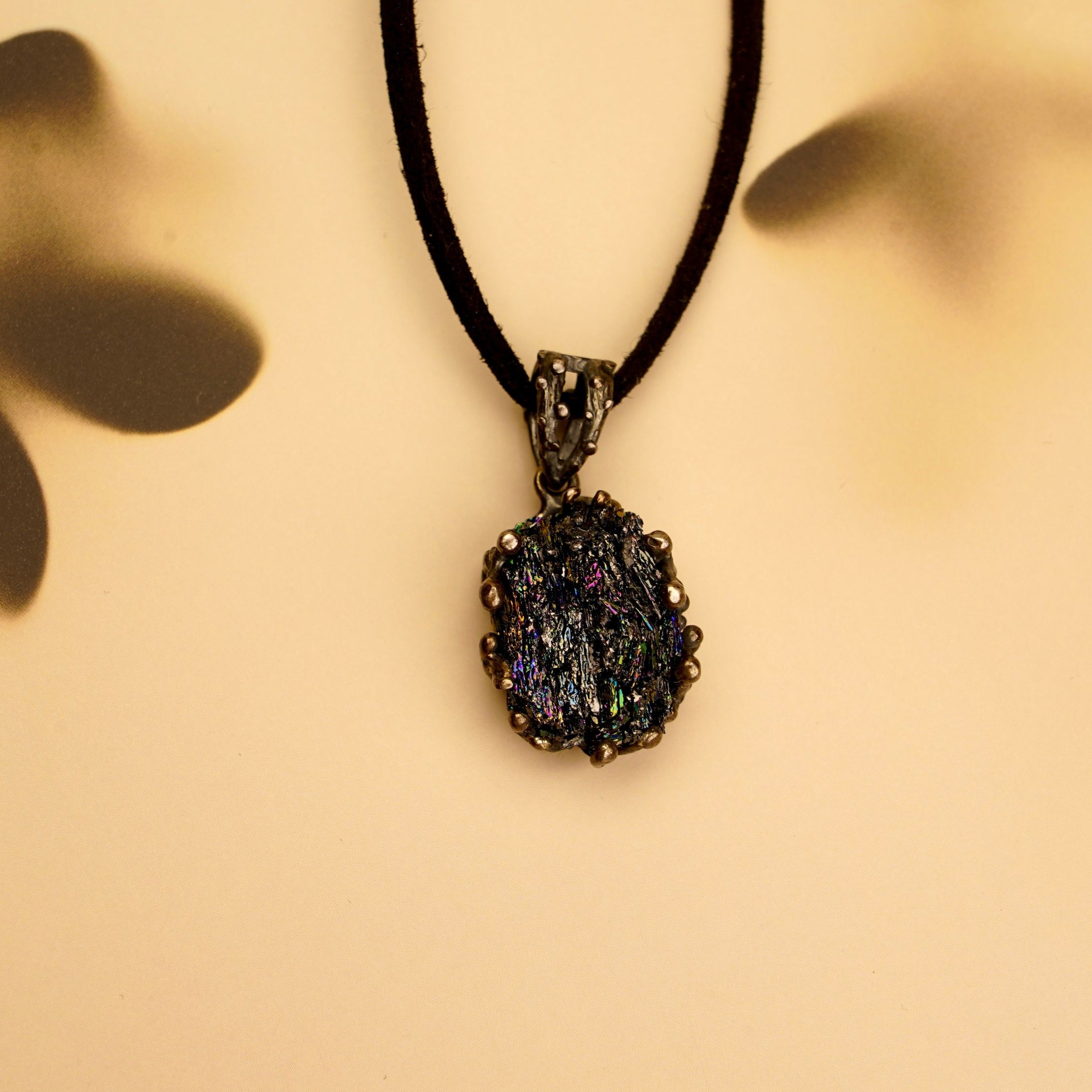 Detail shot of the Obsidian necklace on a textured stone surface, perfect for gothic and alternative fashion styles