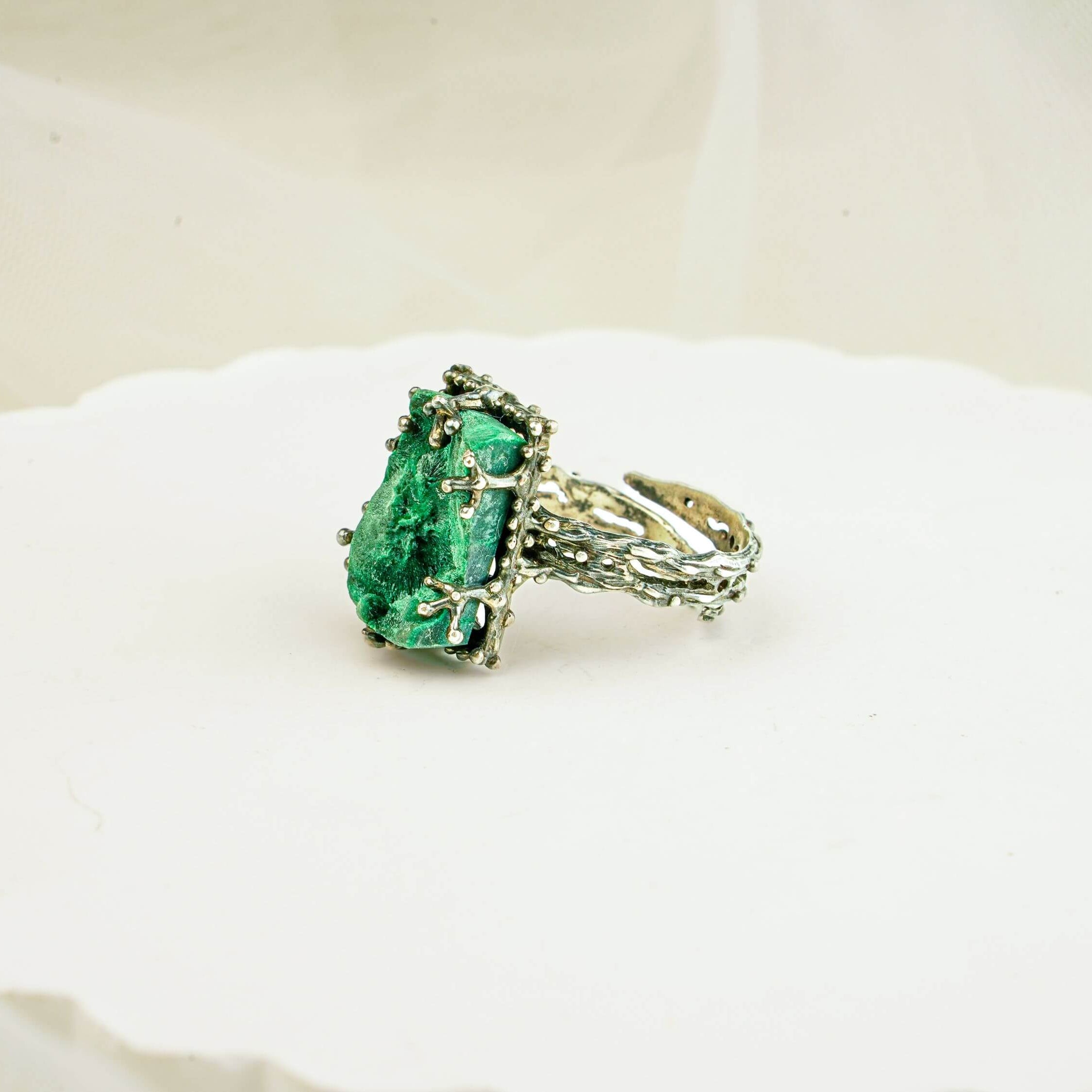 Side view of adjustable malachite ring showcasing the detailed vine-like silver craftsmanship