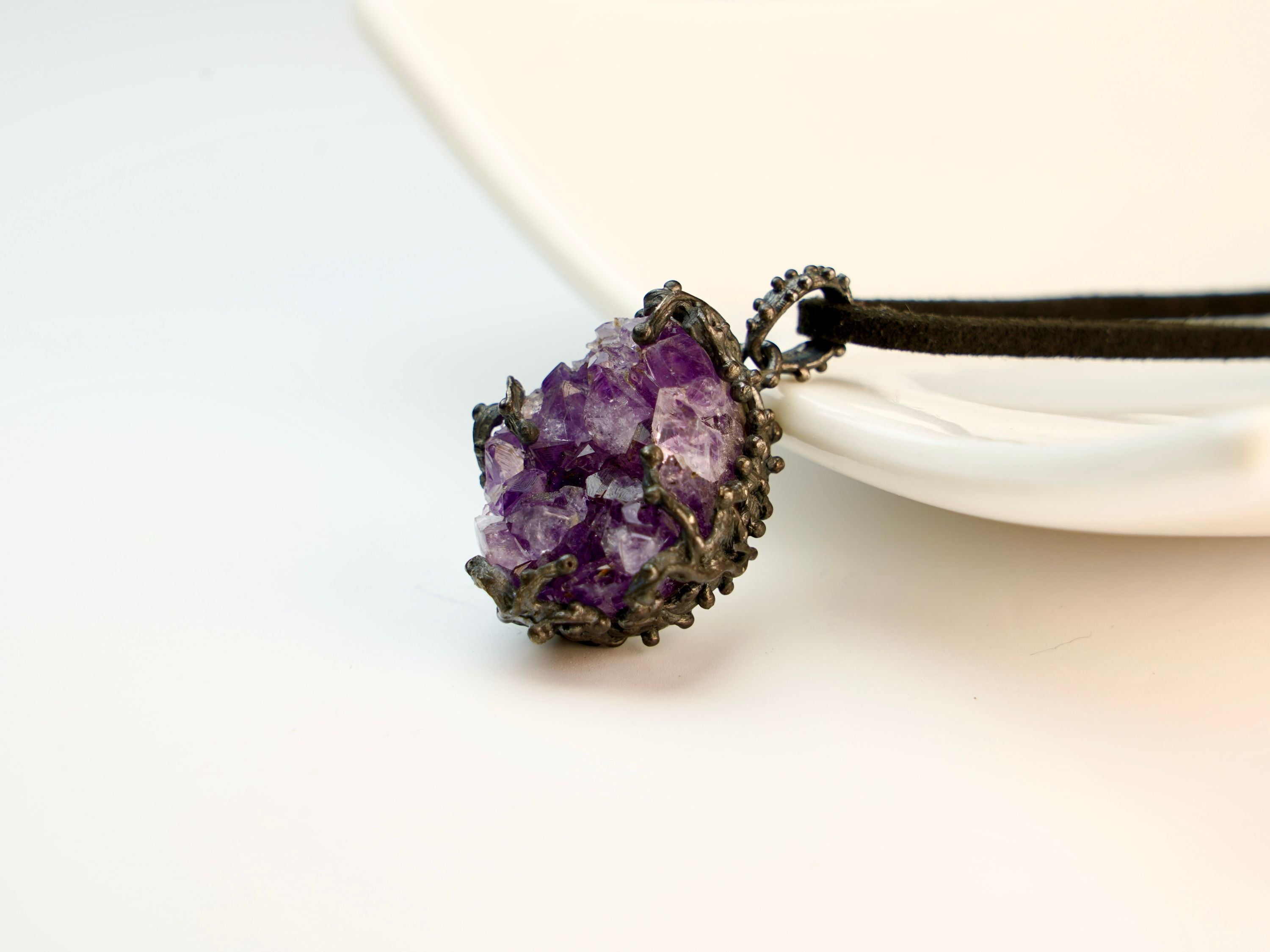 amethyst crystal pendant angled view, purple gemstone jewelry aesthetic