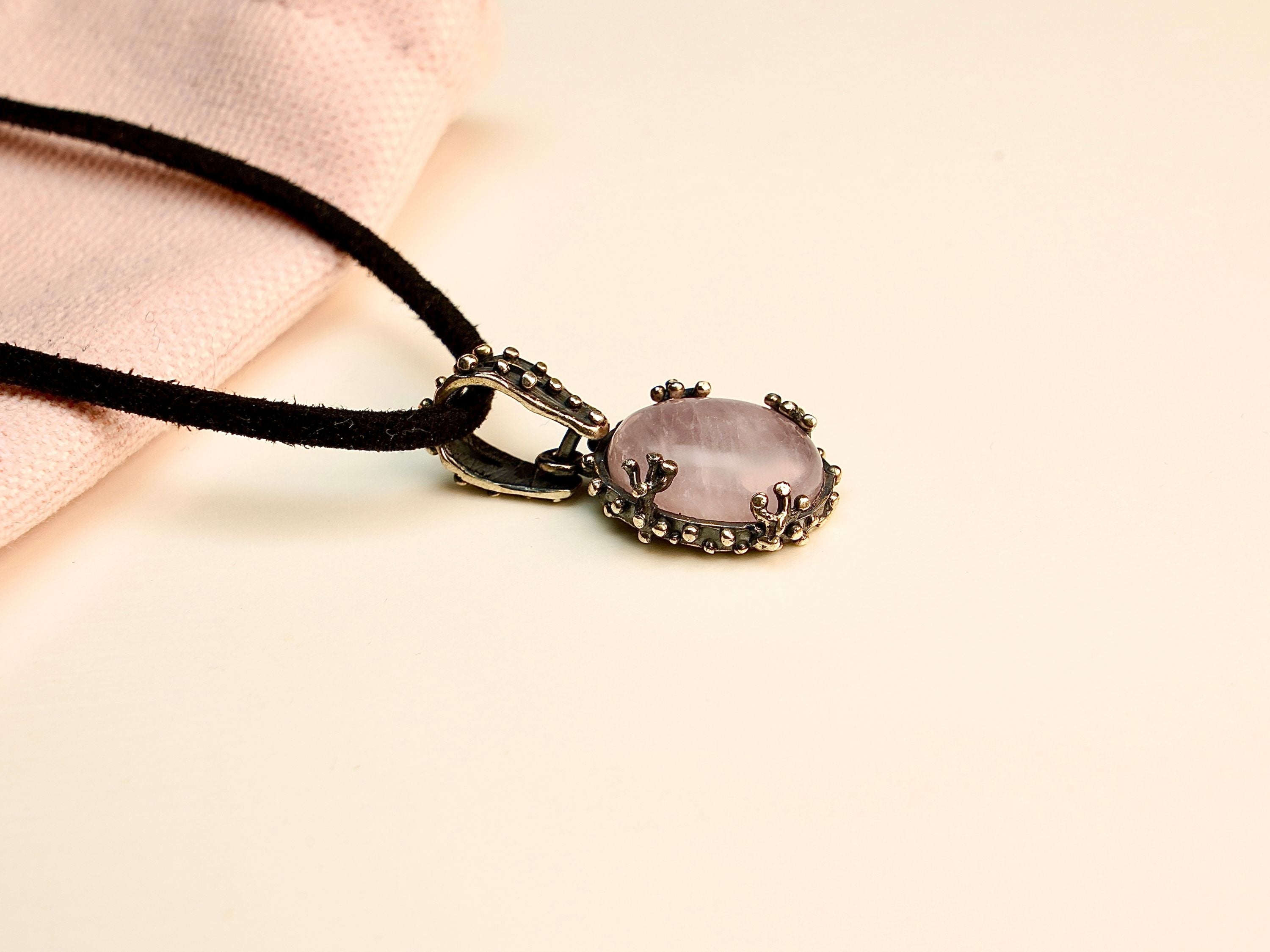 Rose quartz necklace angle view pink gemstone pendant elegant silver jewelry