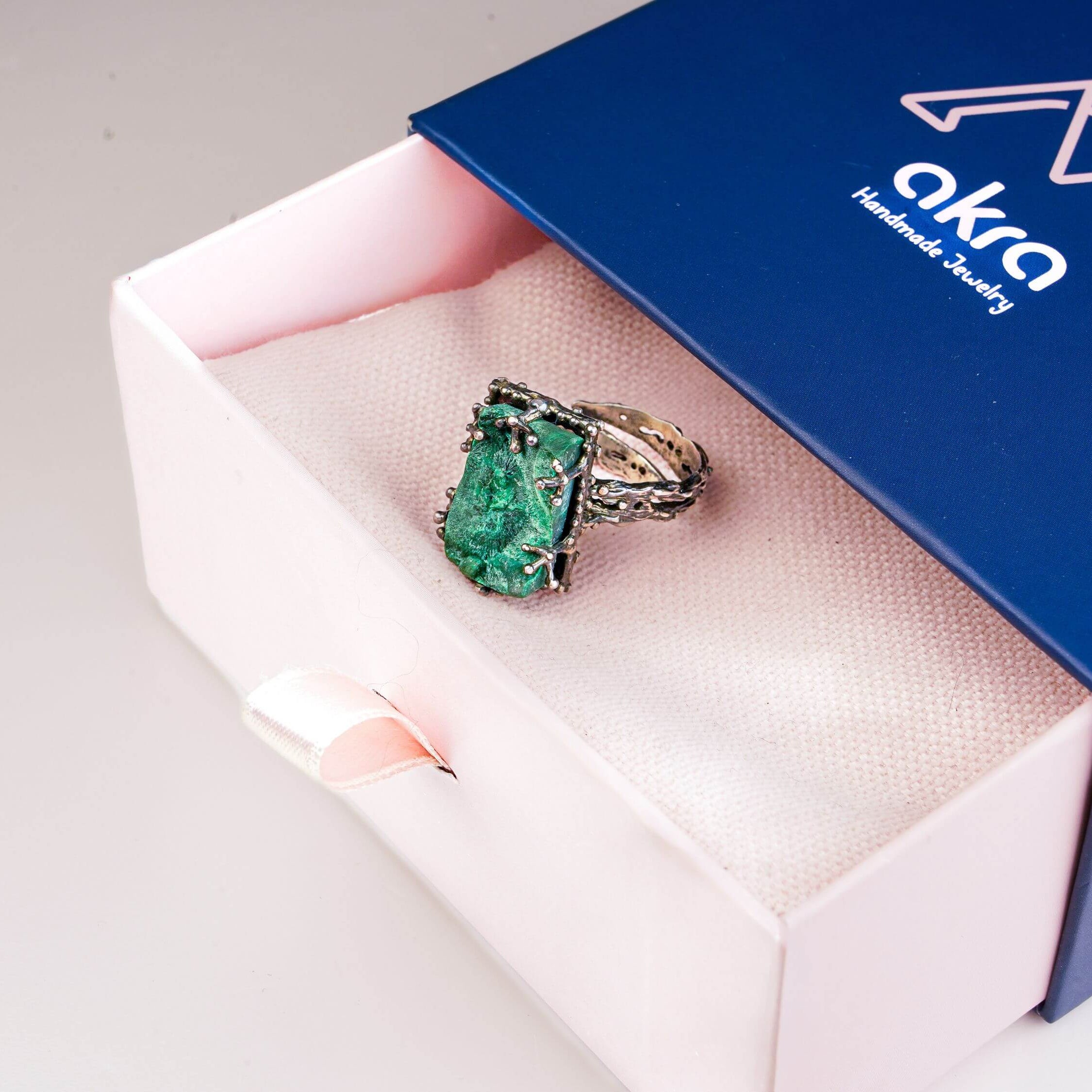 Akra Gems signature luxury blue and pink gift box packaging with malachite ring inside
