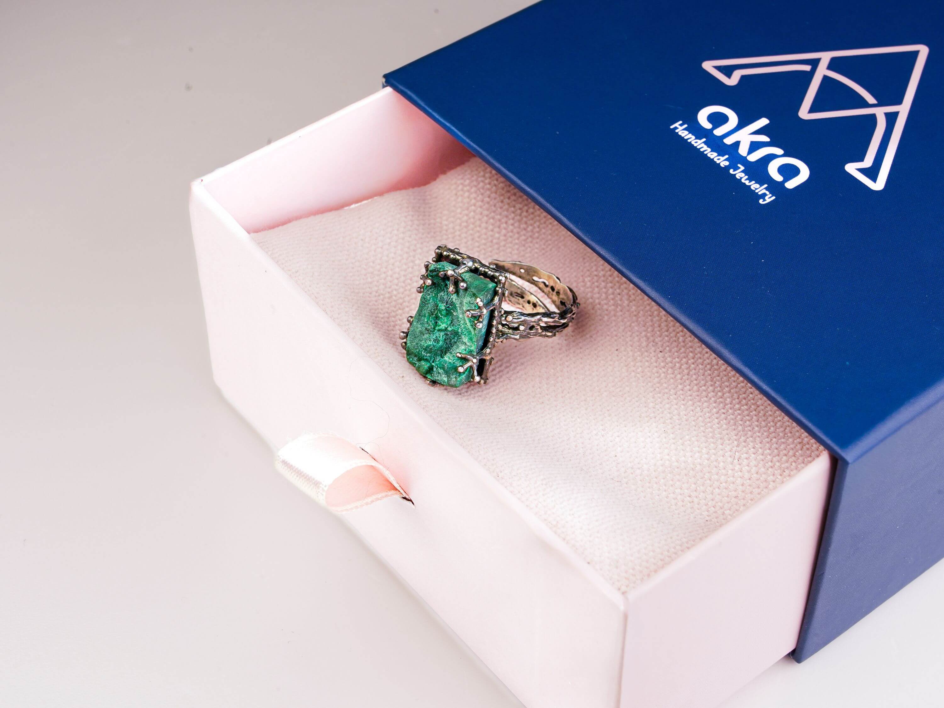 Akra Gems signature luxury blue and pink gift box packaging with malachite ring inside