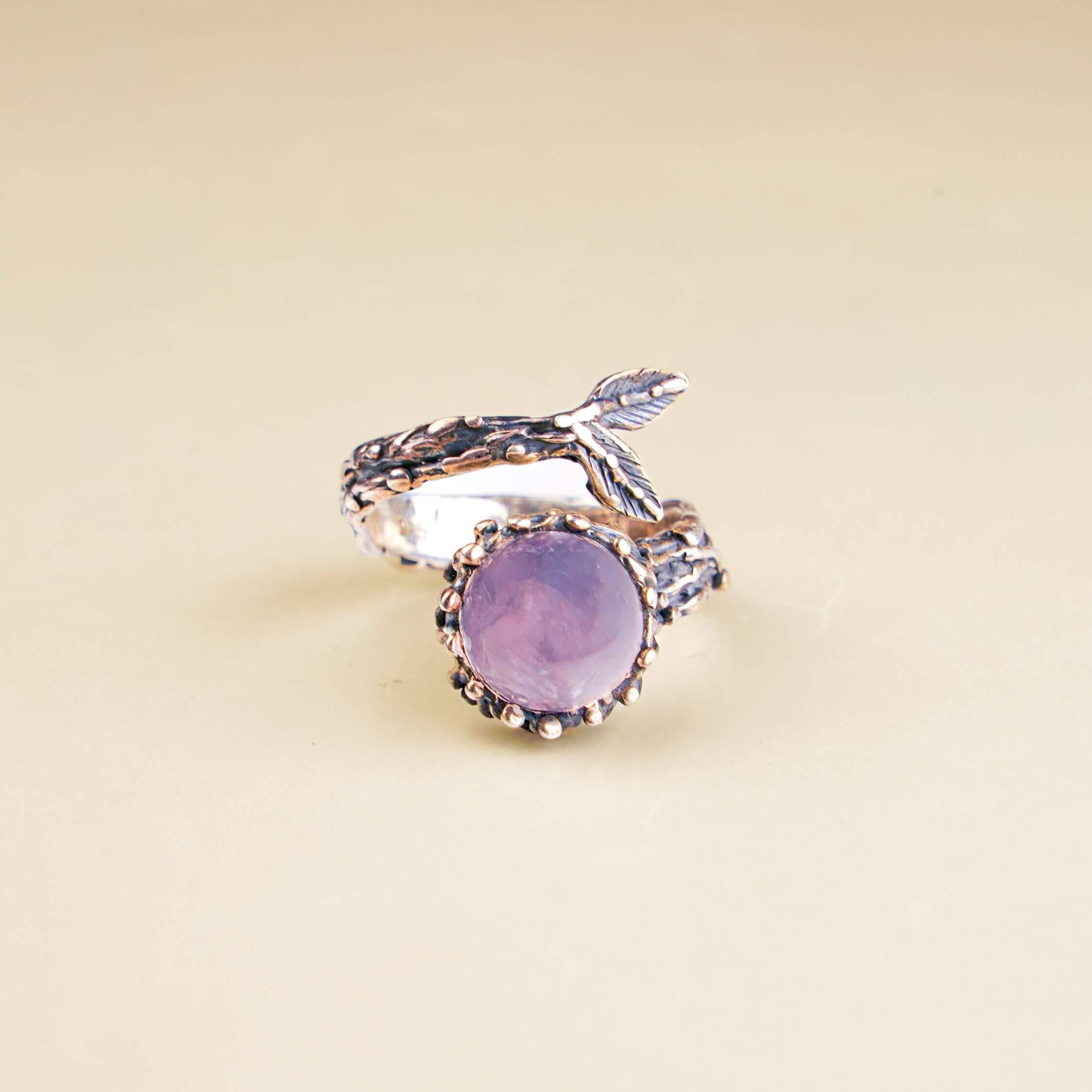 Bohemian rose quartz gemstone ring displayed on a minimalist white geometric pedestal