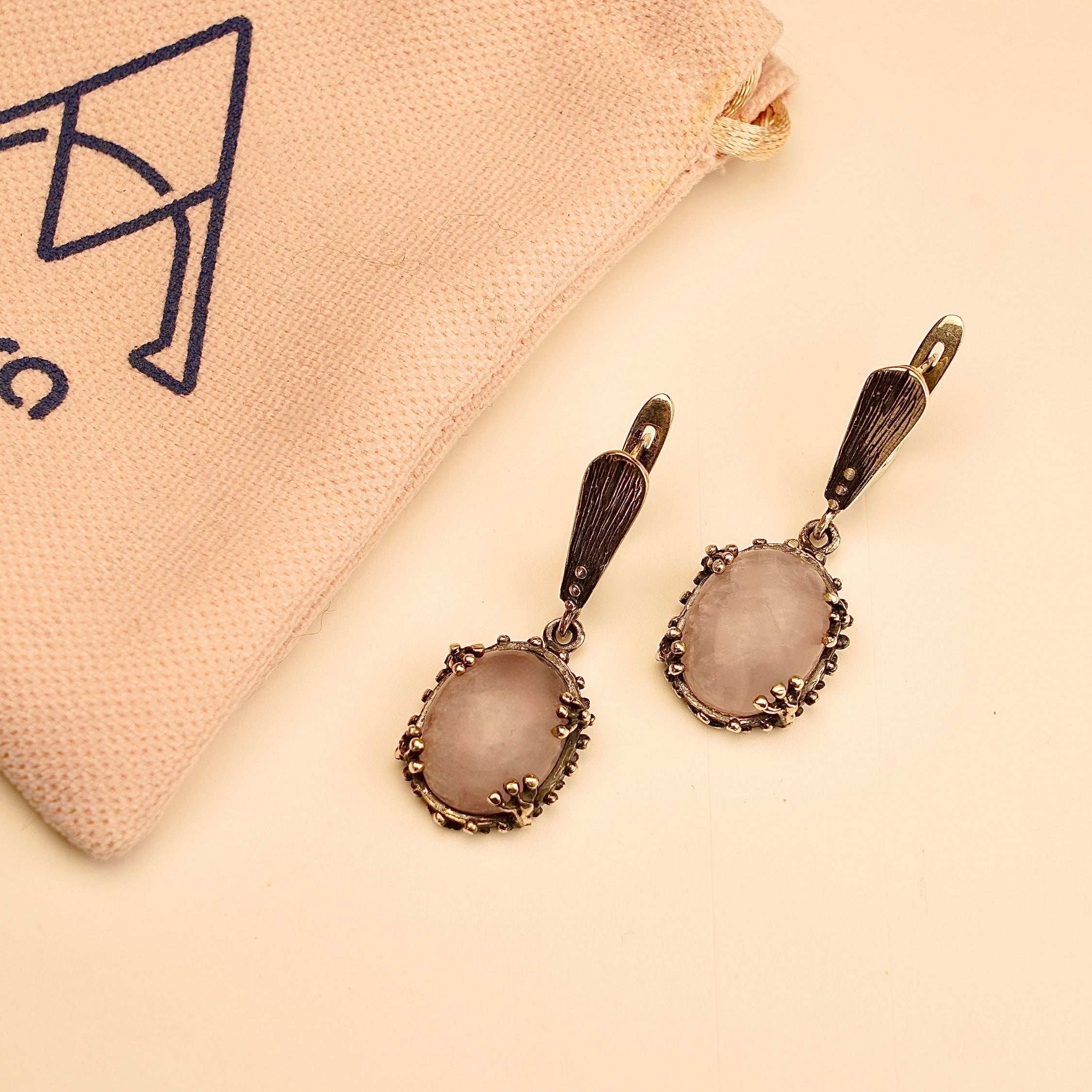 rose quartz earrings detail view, polished pink stone and silver craftsmanship