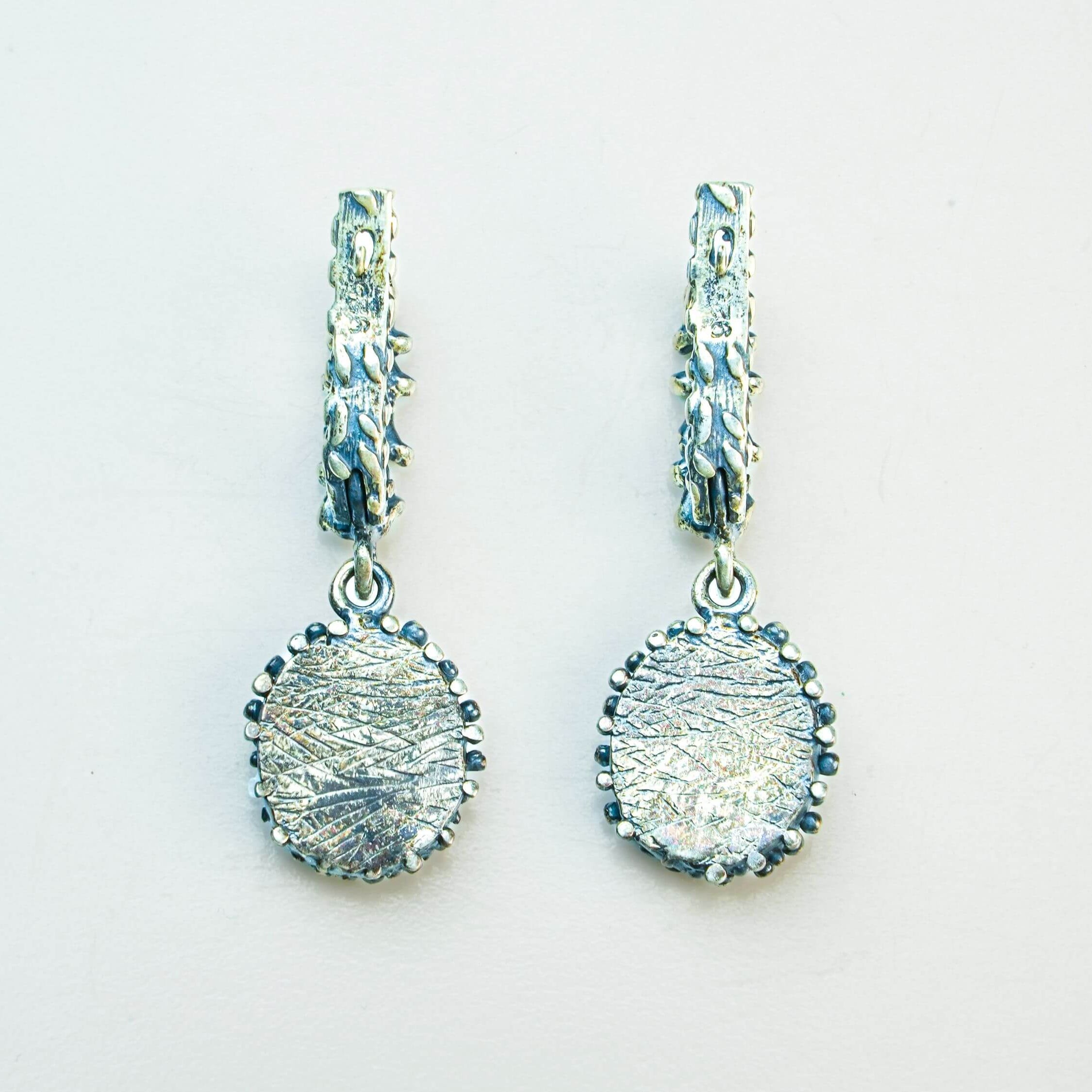 The reverse side of the Malachite earring, showing the hypoallergenic 925 sterling silver stamp, smooth silver setting, and secure ear wire closure