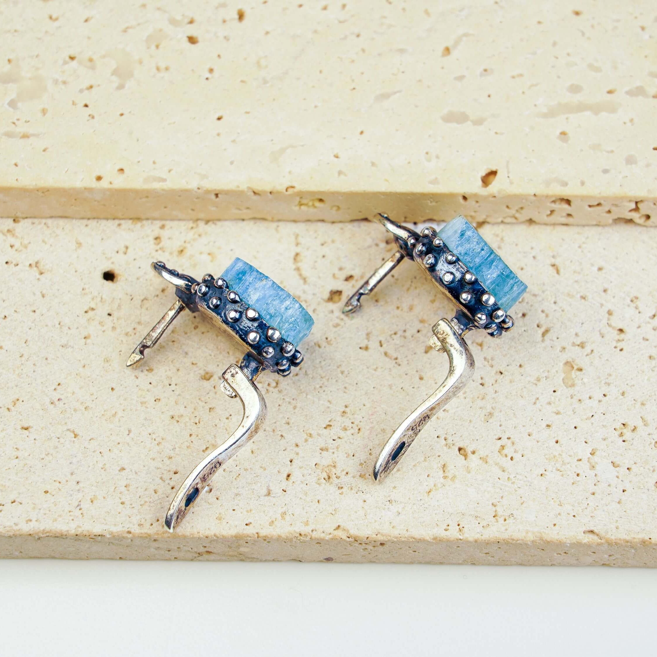 Top-down layout of the silver aquamarine earrings showing the open-back setting for light transparency