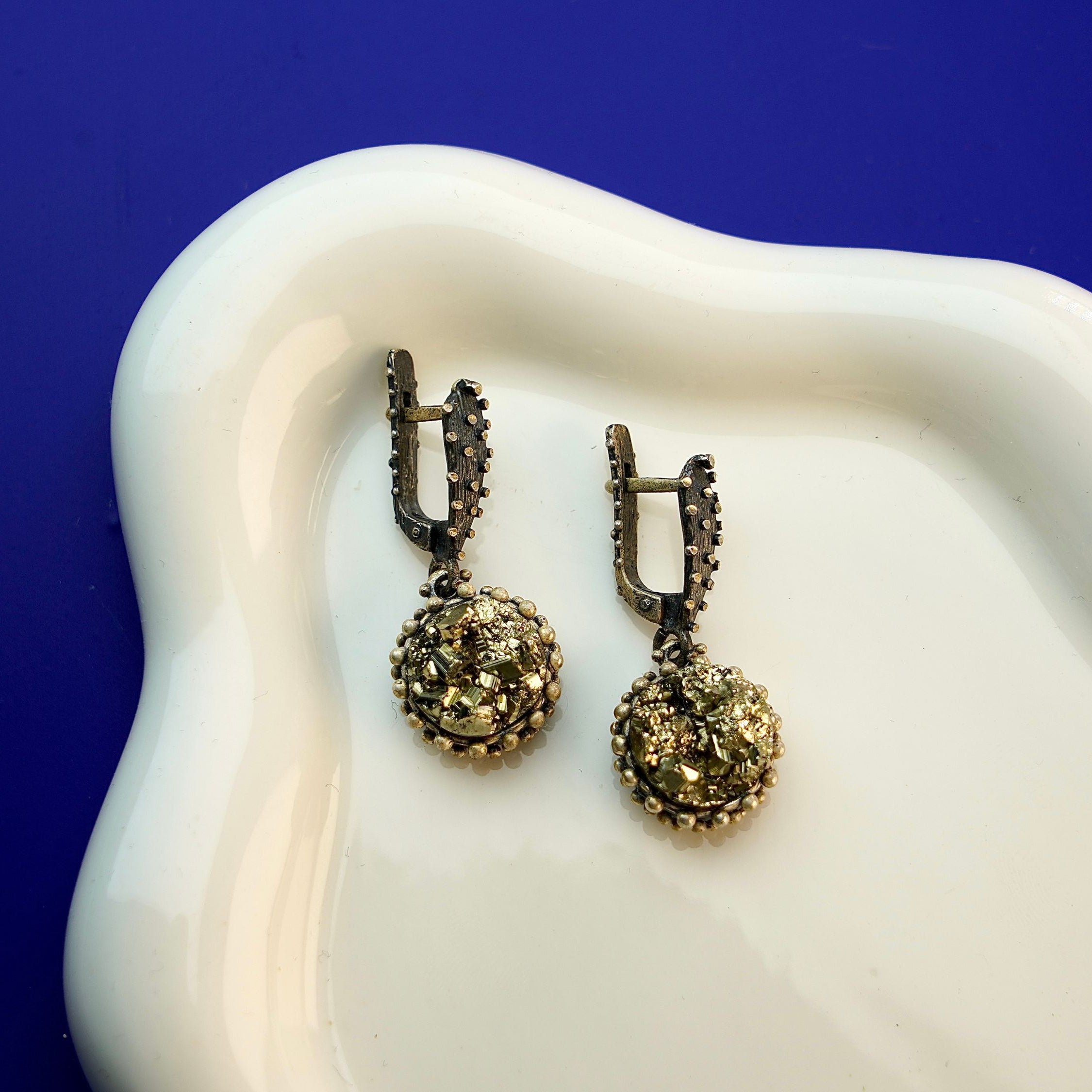 Lifestyle pyrite earrings metallic gold statement jewelry styled composition