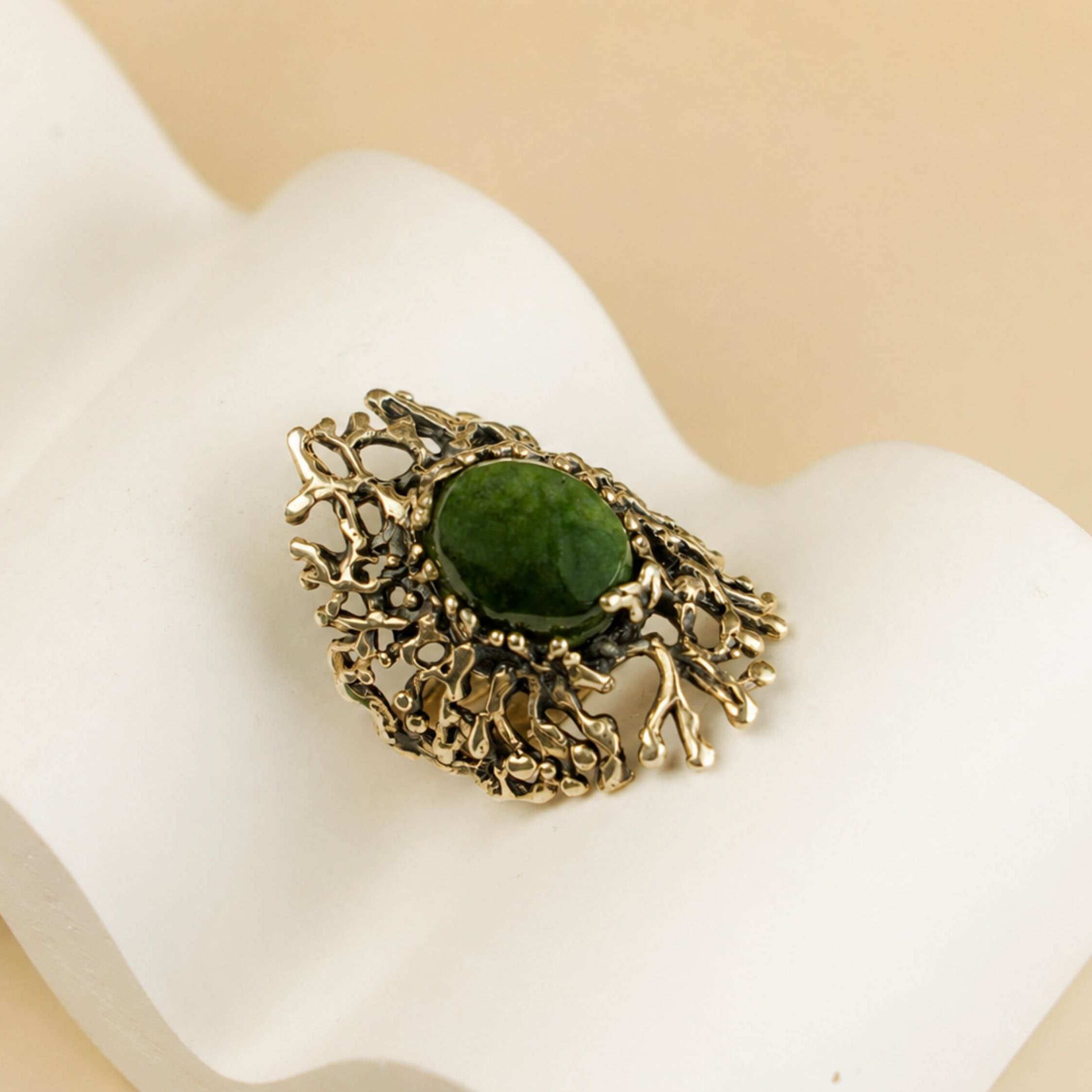 Top-down view of the handcrafted Jade ring, showcasing the complex and unique silver patterns surrounding the green gemstone.