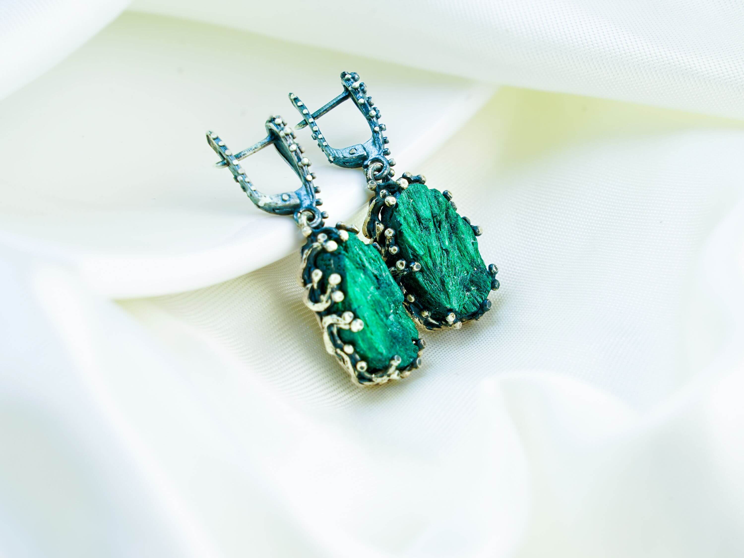 A pair of artisan malachite earrings, showcasing unique natural stones handcrafted by Akra Gems in Tbilisi