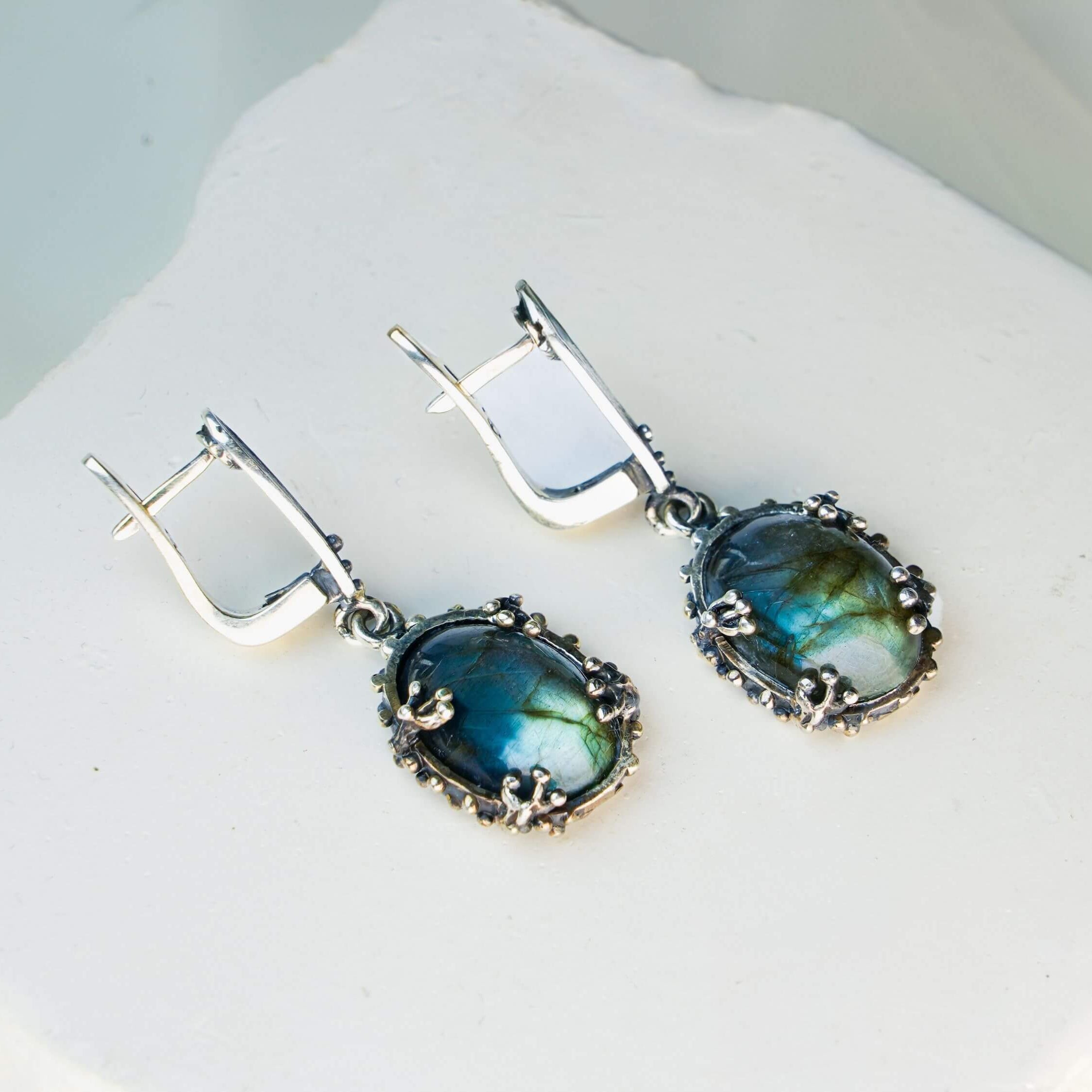 Front view of labradorite dangle earrings, showing the symmetrical design and silver craftsmanship