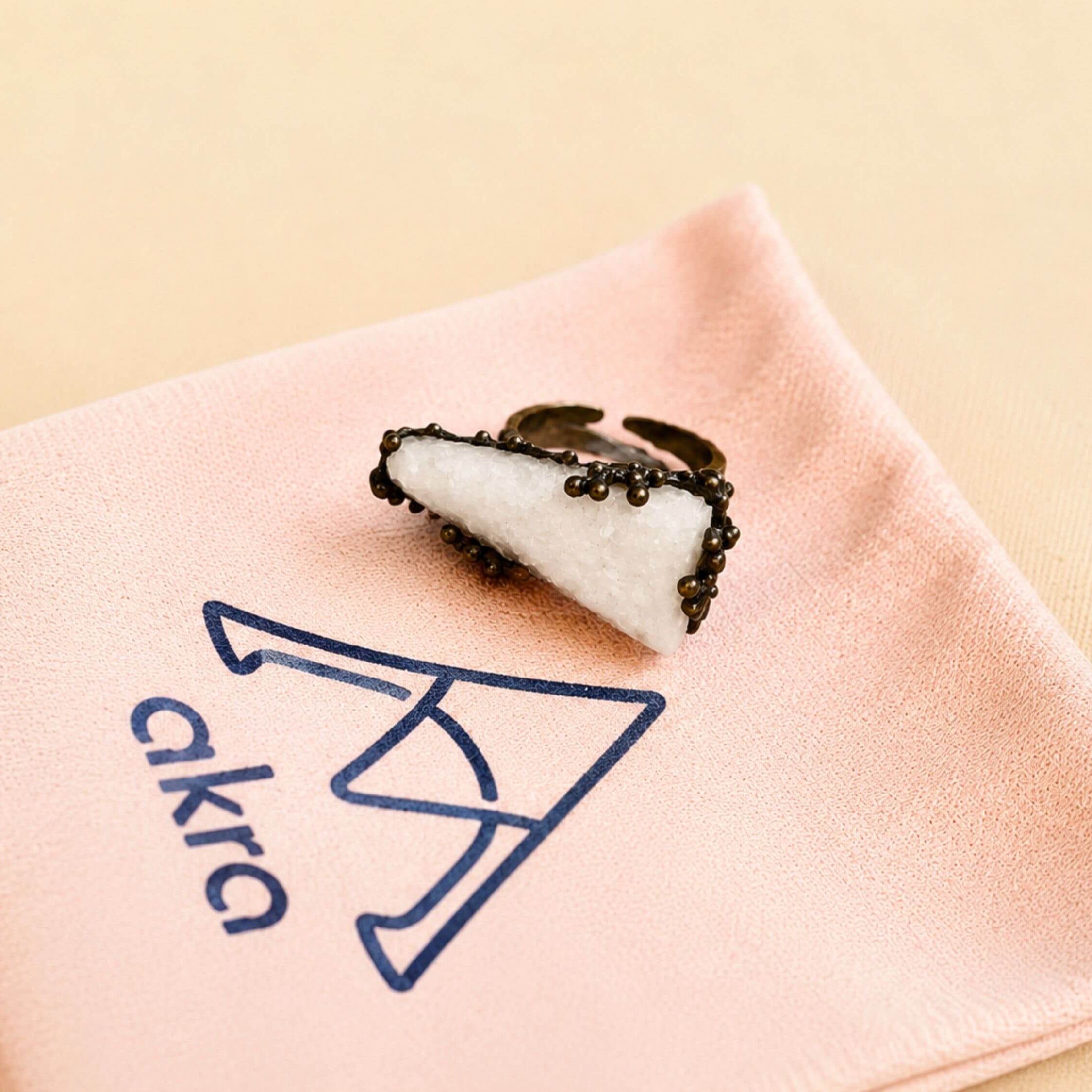 Artistic shot of the statement Moonstone ring resting on an Akra Gems branded pink jewelry pouch, capturing its boho-chic aesthetic.