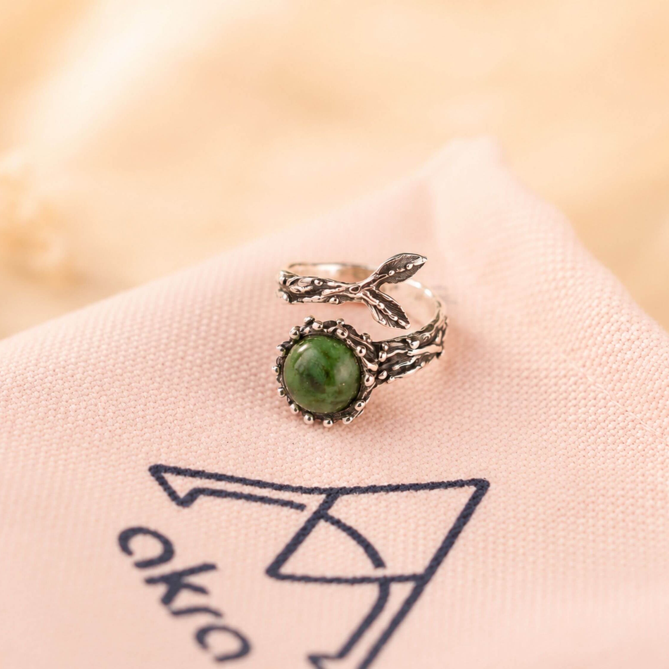 Mystical aesthetic shot of the raw green Jade ring, capturing its natural earthy energy and sophisticated handcrafted vibe.