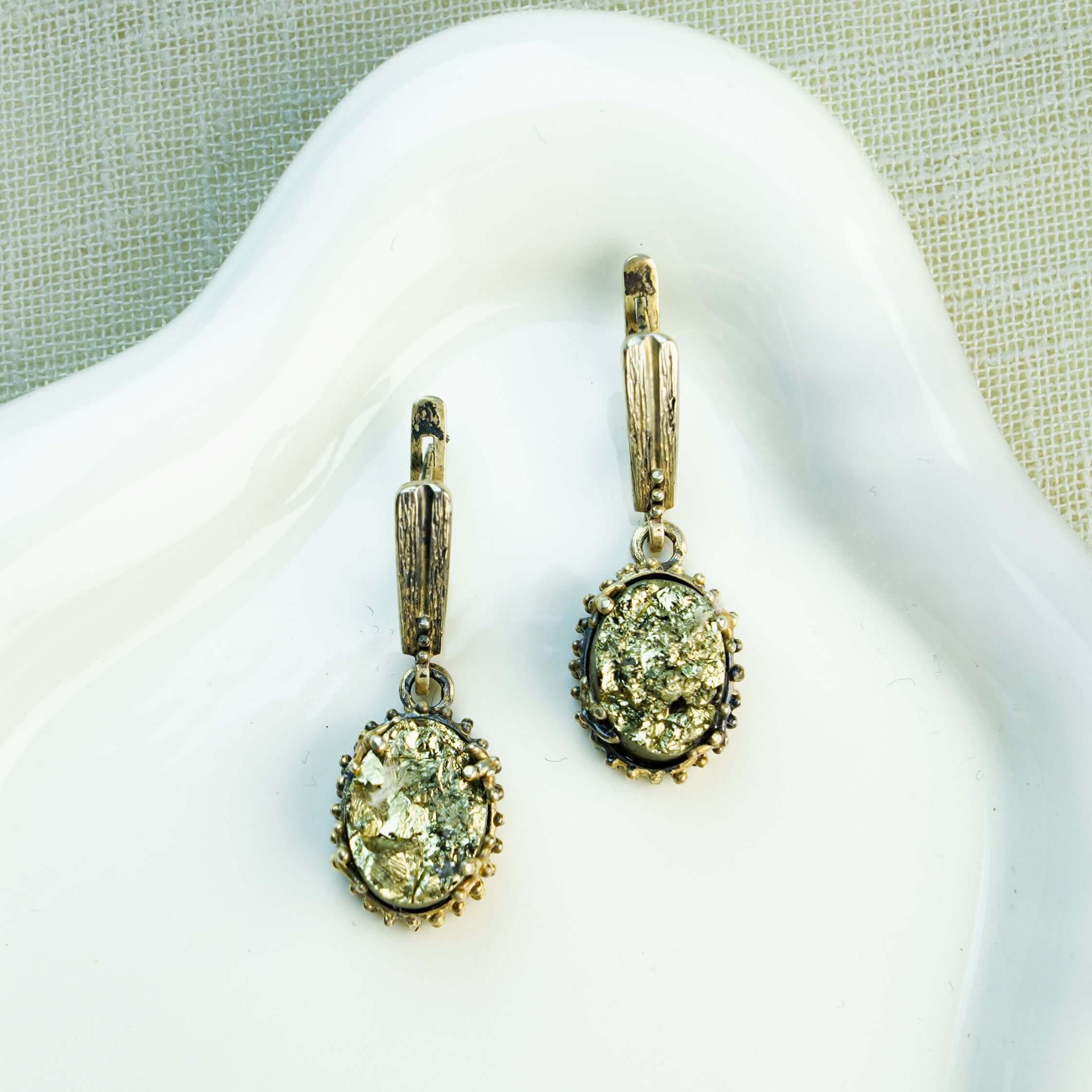 Oval Golden Pyrite earrings featuring glistening metallic gemstones in a detailed sterling silver frame, displayed on a clean background