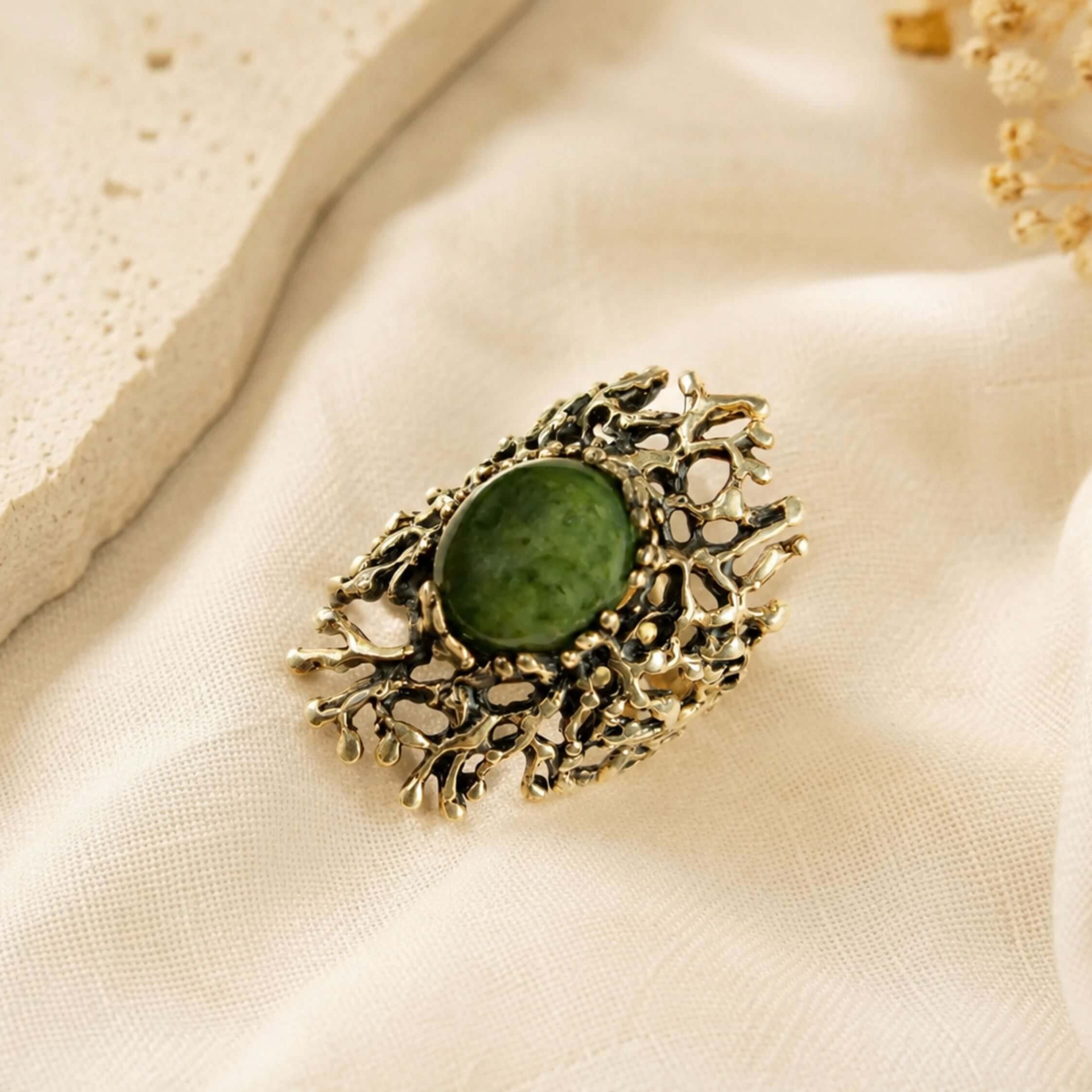 Top-down view of the handcrafted Jade ring, showcasing the complex and unique silver patterns surrounding the green gemstone.