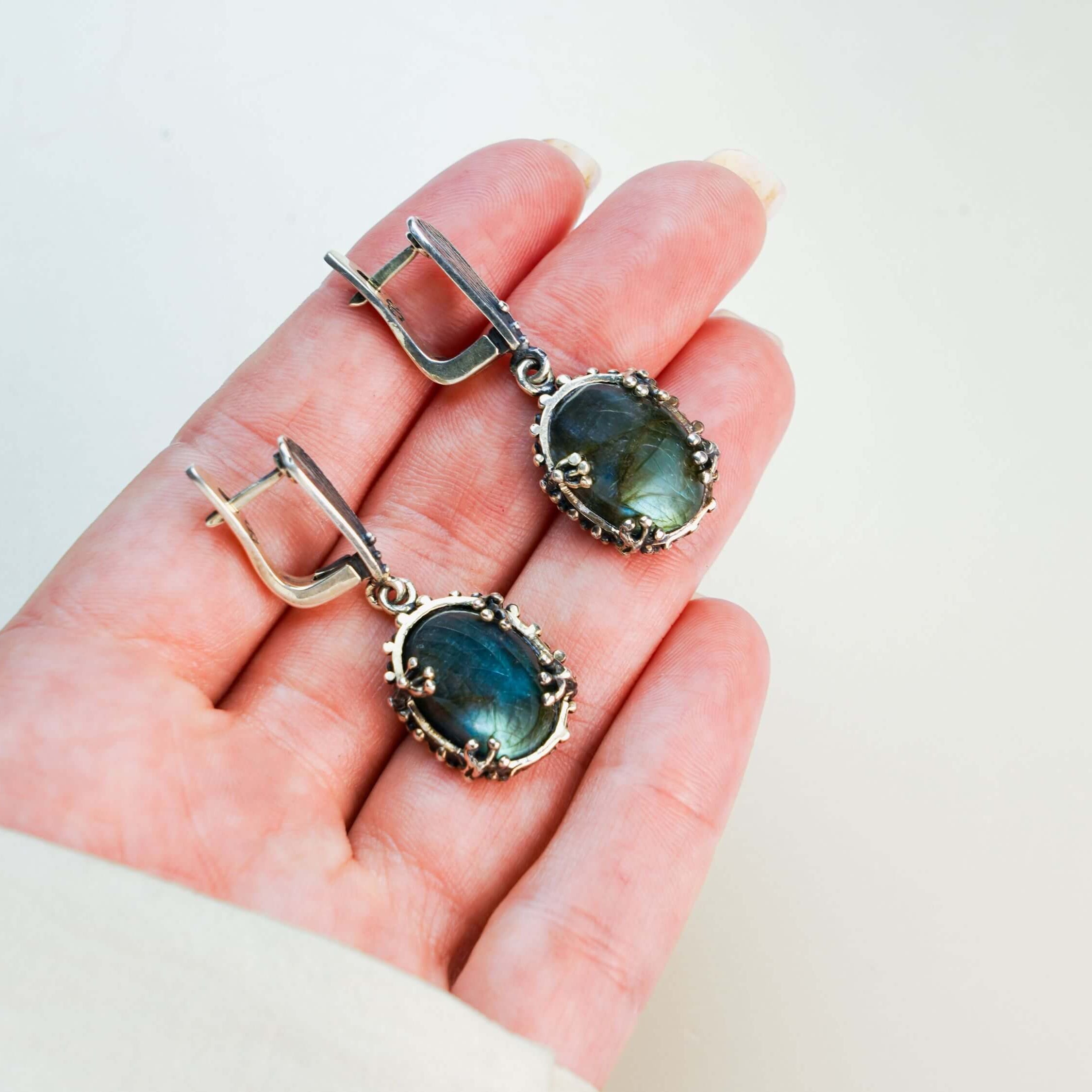 Labradorite drop earrings held in hand to demonstrate the actual size and scale of the gemstone