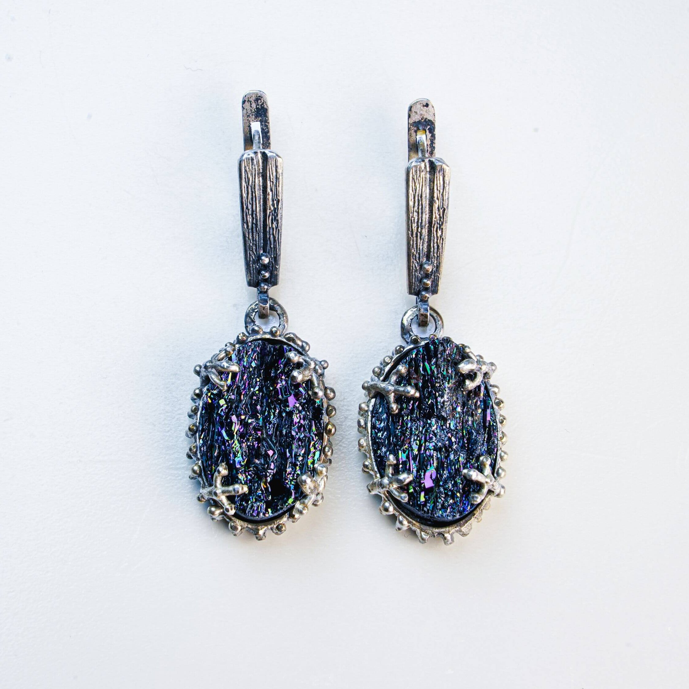 Front-facing symmetrical shot of the tourmaline earrings, emphasizing the contrast between the dark stone and the detailed oxidized silver