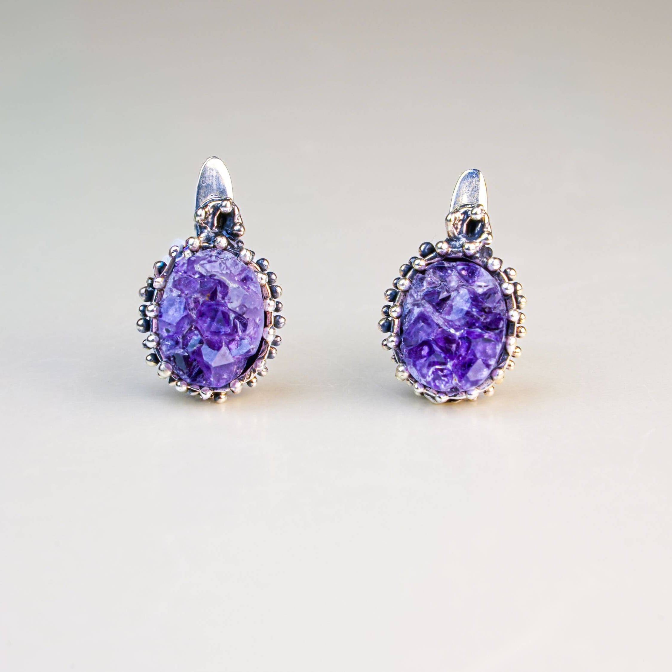 Direct front-facing view of the oval crystal earrings, emphasizing the symmetry and the intricate silver textures