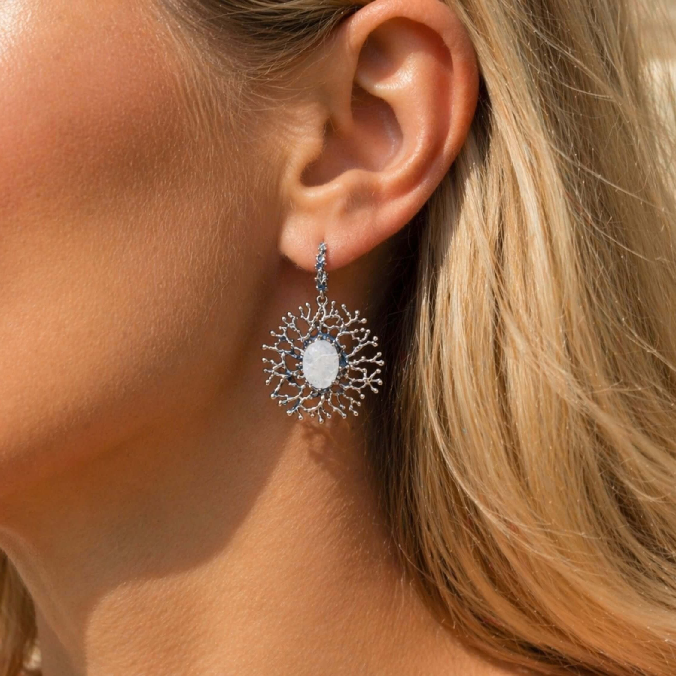 Lifestyle view of a woman wearing Akra Gems branch-style Moonstone earrings, showing the artistic scale and organic flow of the jewelry