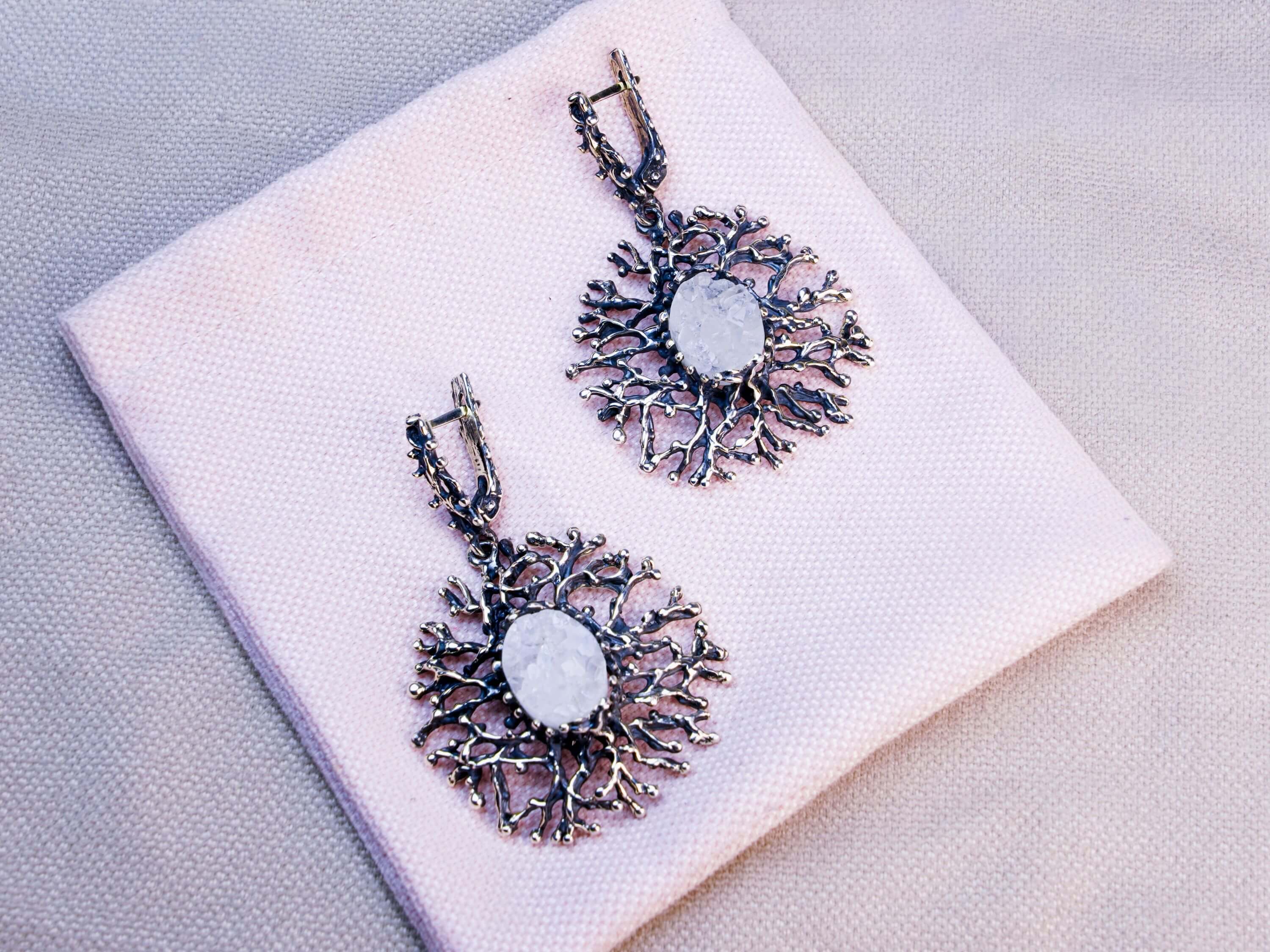 Mystical aesthetic shot of Moonstone earrings paired with natural elements, highlighting the raw and organic jewelry design