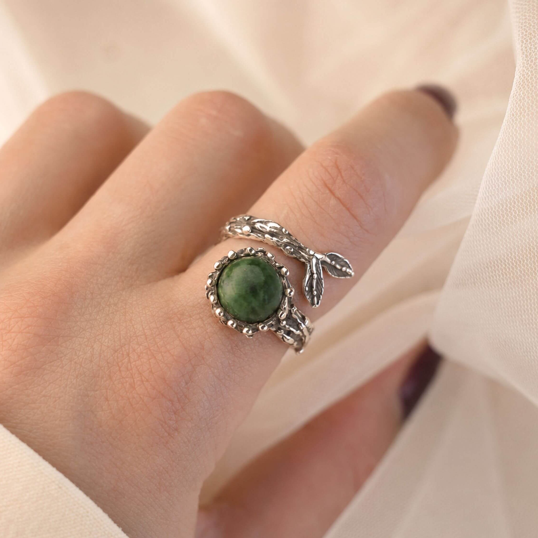 A model wearing the raw Jade ring on a finger, showing its bold scale and how the vibrant green gemstone stands out as a statement piece.