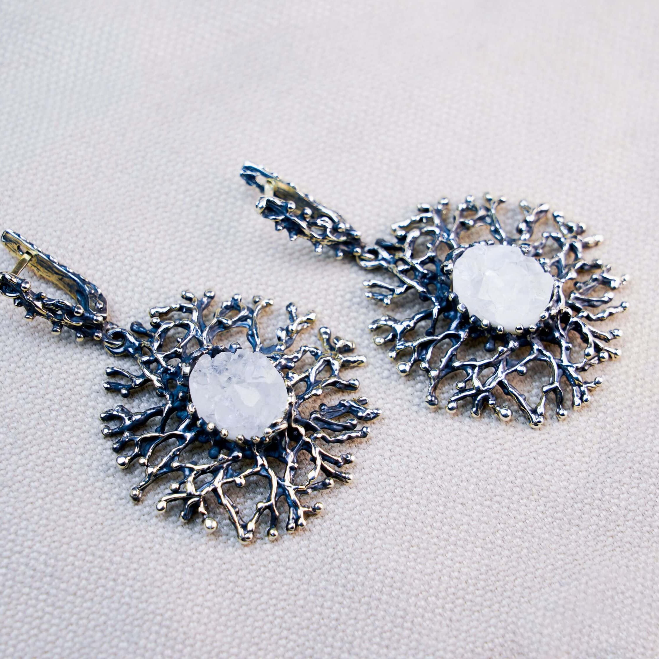 Macro shot of a natural white Moonstone with an ethereal blue glow, nestled in a handcrafted oxidized silver branch setting