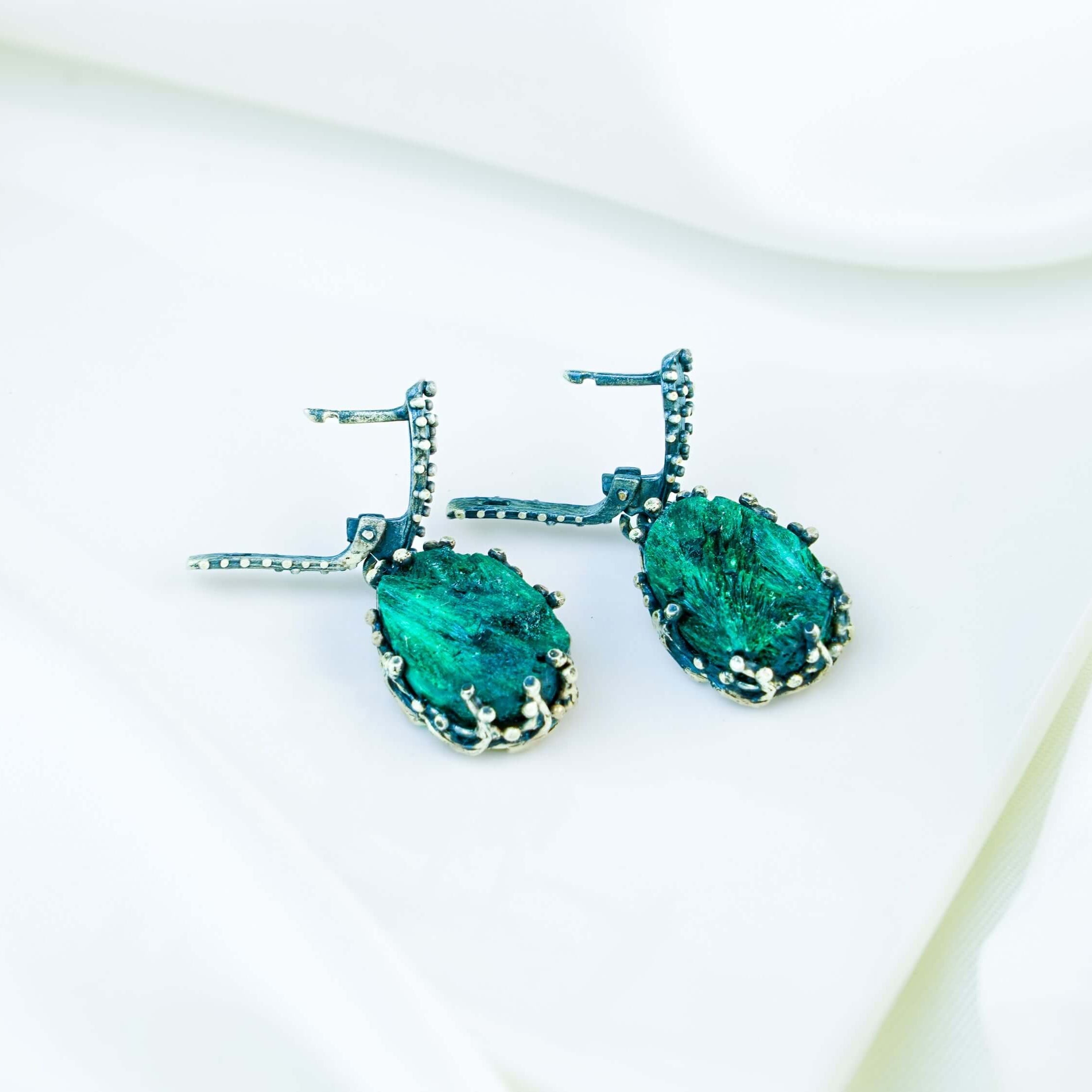 Side profile of the teardrop dangles, showing the depth of the stone and the intricate 'claw' design of the silver