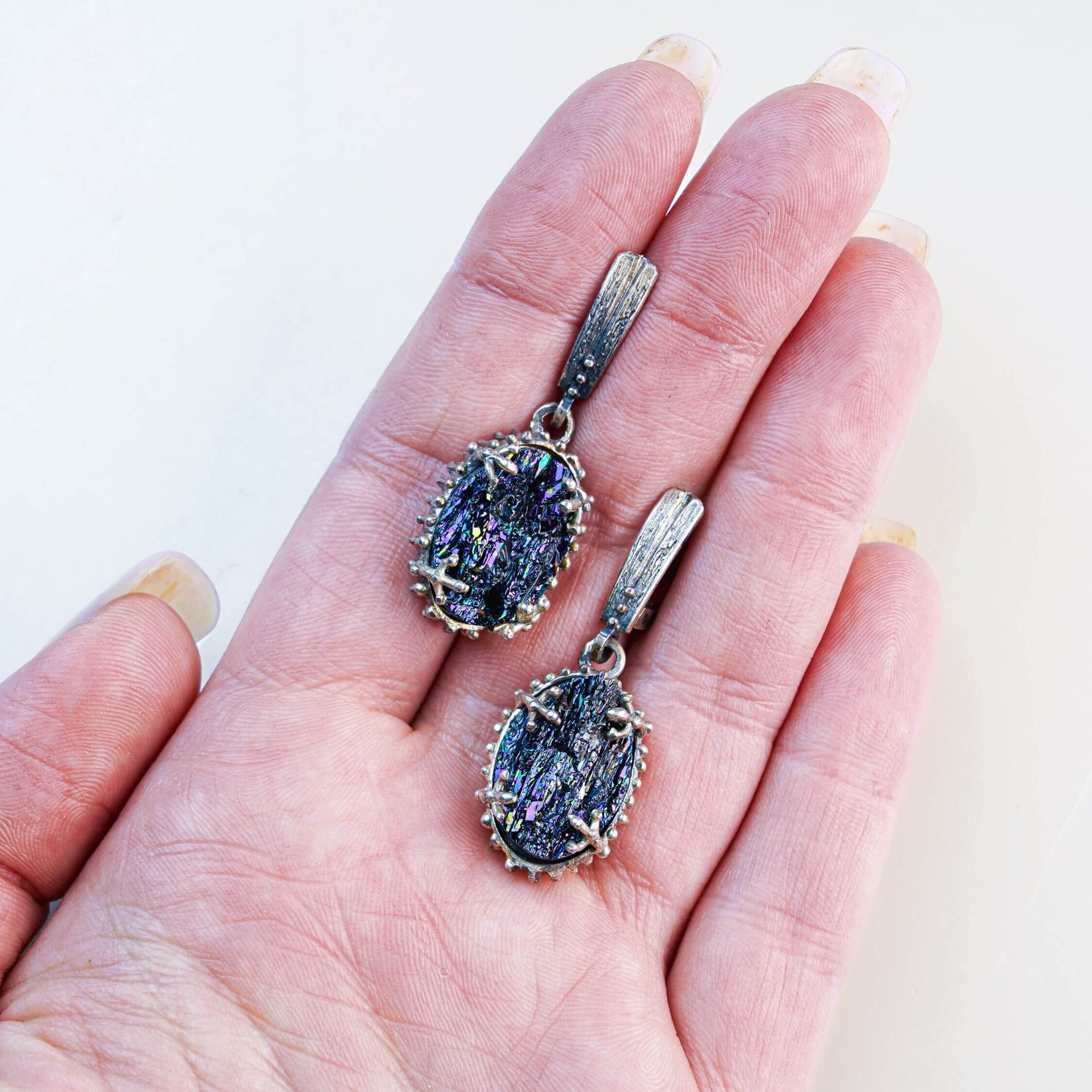Handheld view of both Black Tourmaline dangles, illustrating the substantial statement size and the rich texture of the silver settings