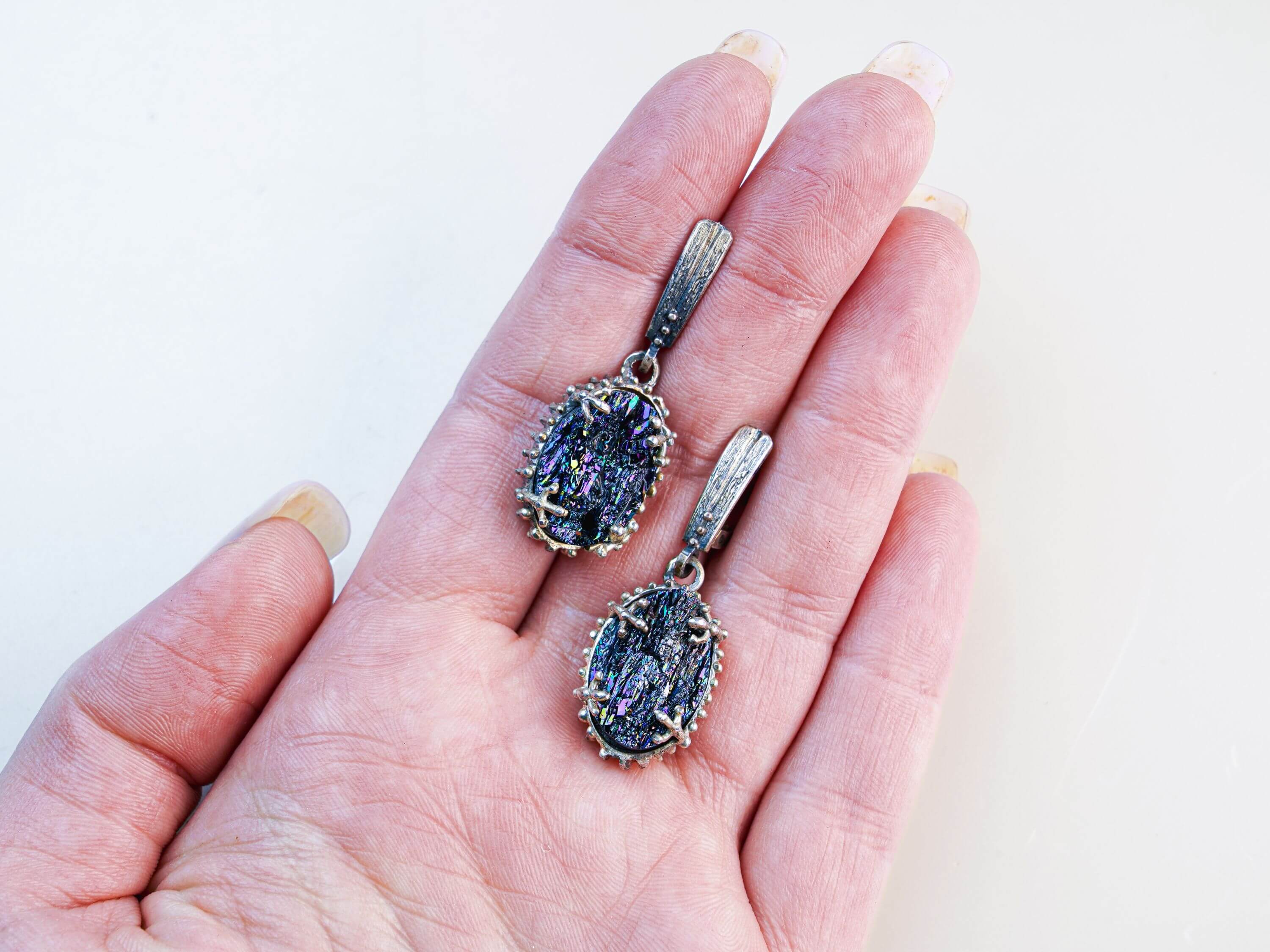 Handheld view of both Black Tourmaline dangles, illustrating the substantial statement size and the rich texture of the silver settings