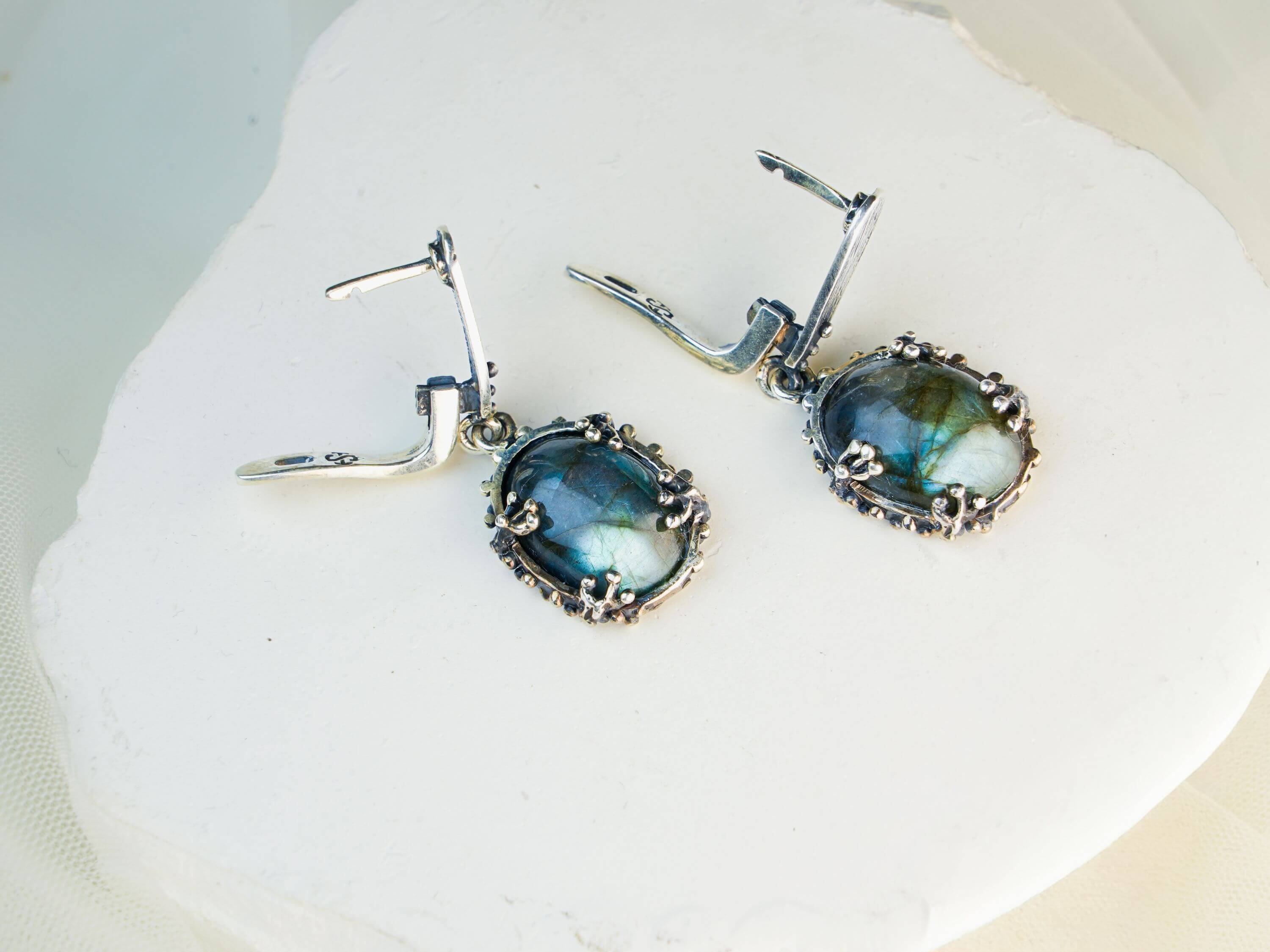 Side profile of blue flash labradorite earrings, highlighting the depth of the natural stone