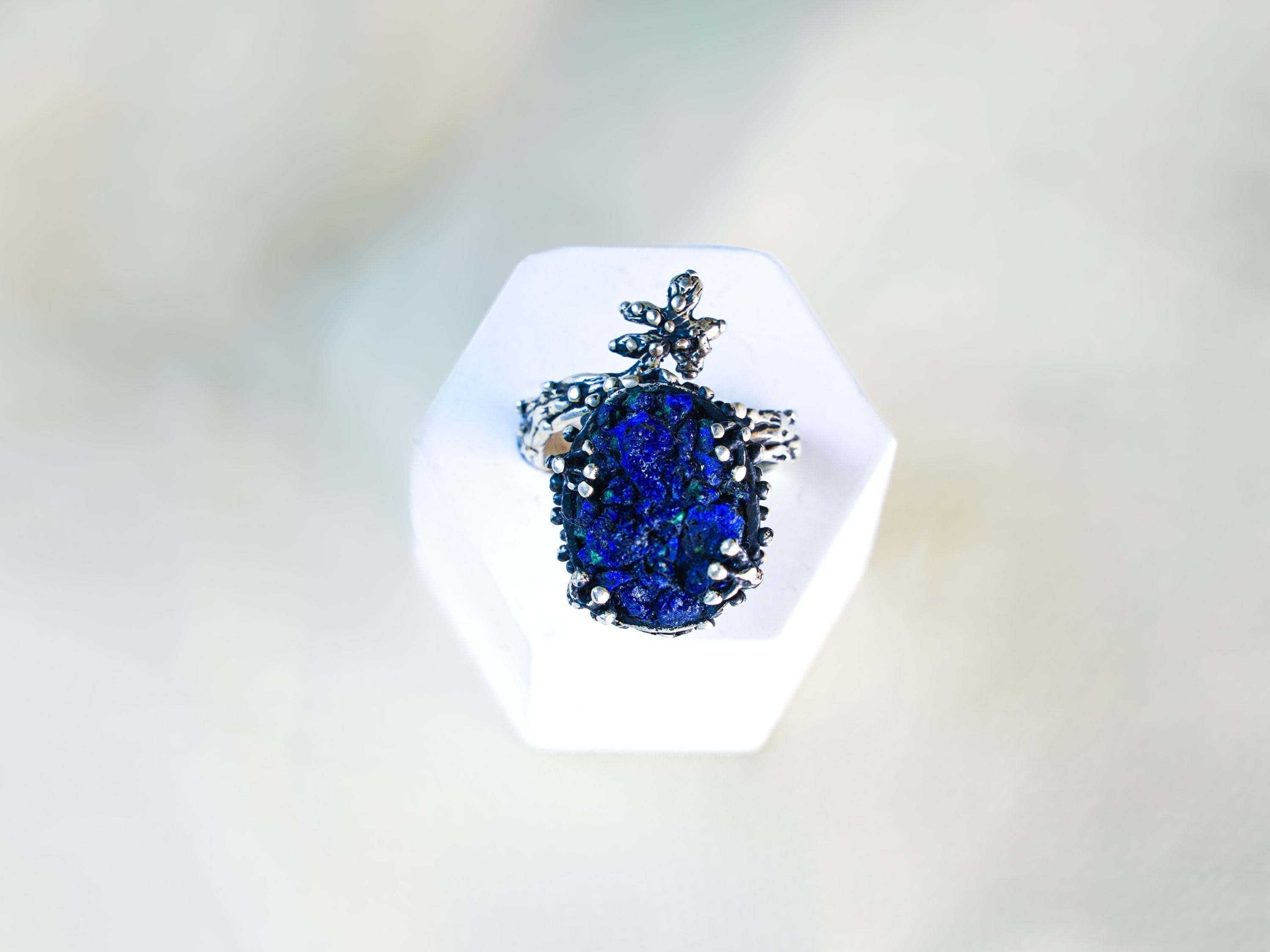 Handcrafted raw lapis lazuli sterling silver ring on a white pedestal